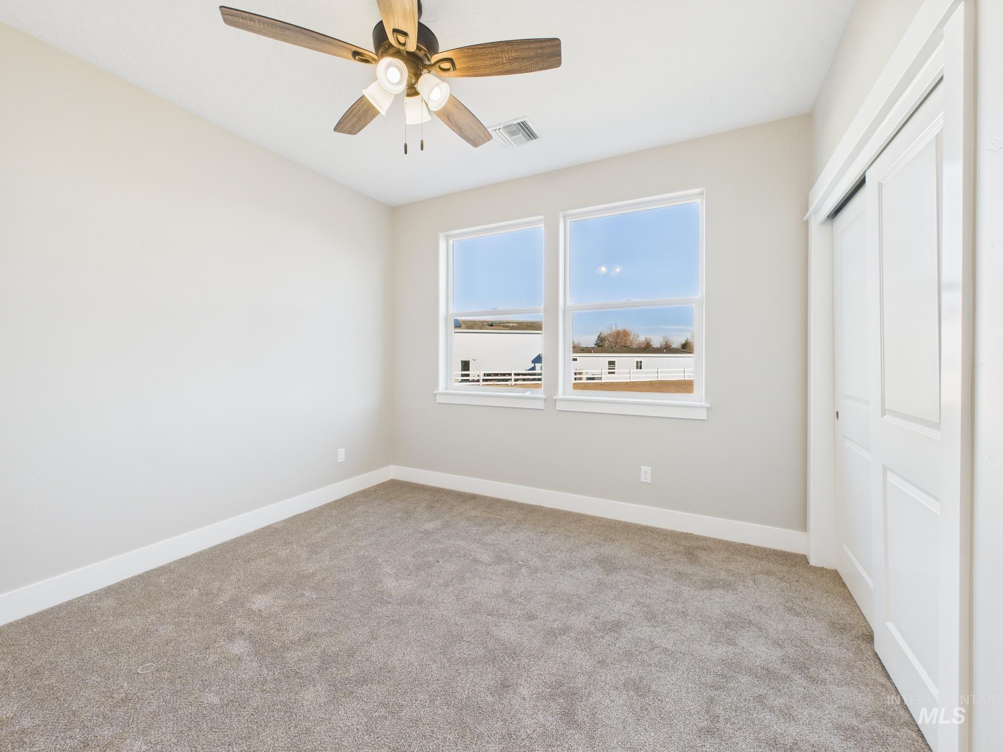 Unfurnished bedroom featuring a closet, light carpet, and a ceiling fan