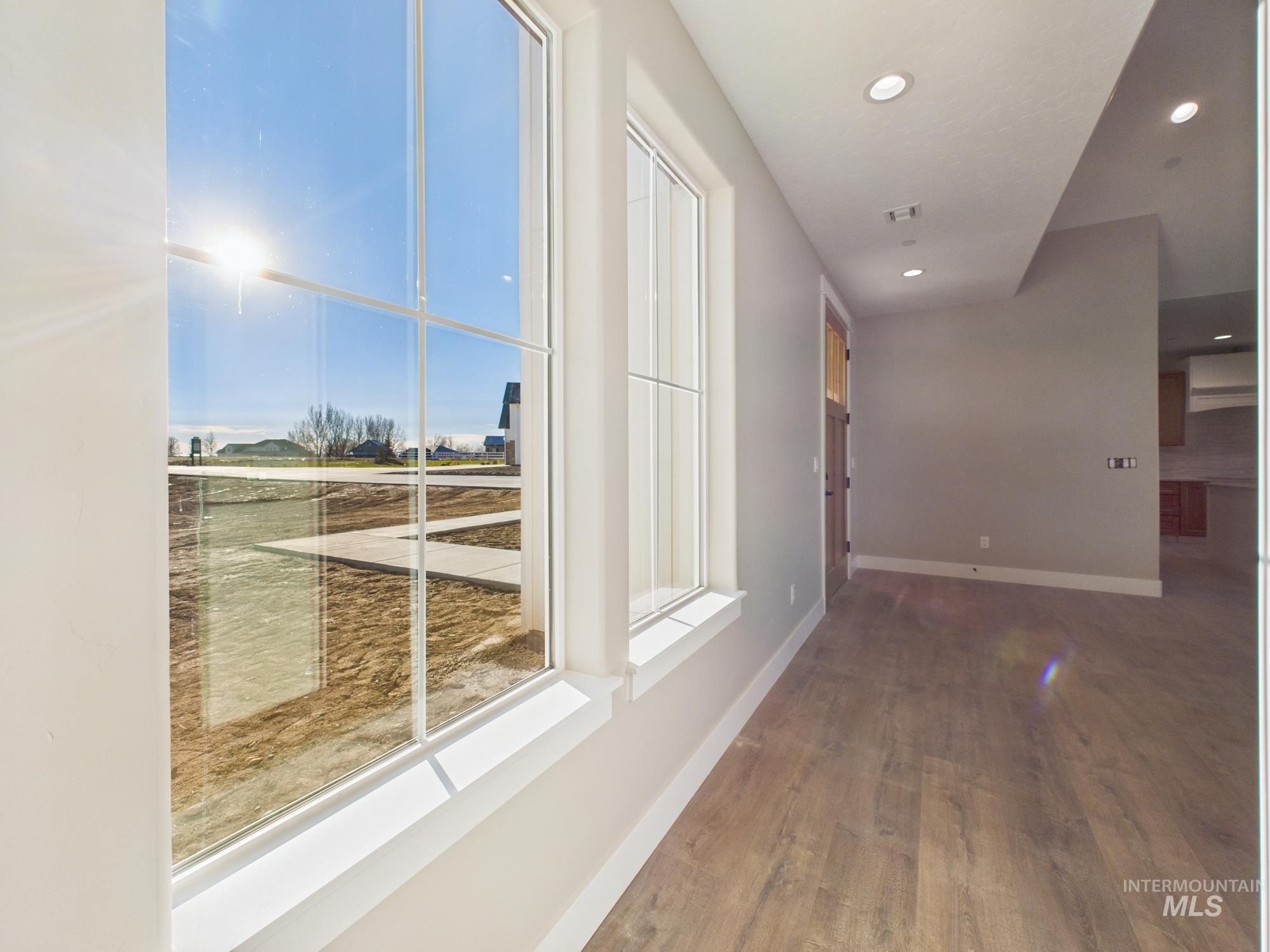 Corridor featuring wood finished floors and recessed lighting