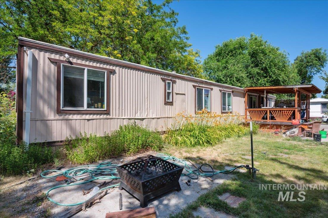 View of front of property featuring an outdoor fire pit, a front yard, and a deck