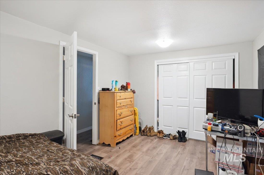 Bedroom with light wood-type flooring and a closet