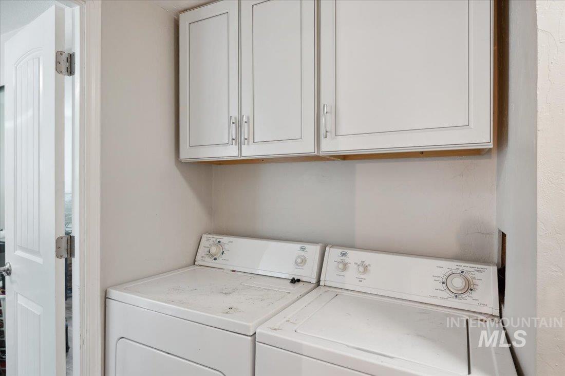 Laundry area featuring washer and clothes dryer and cabinet space