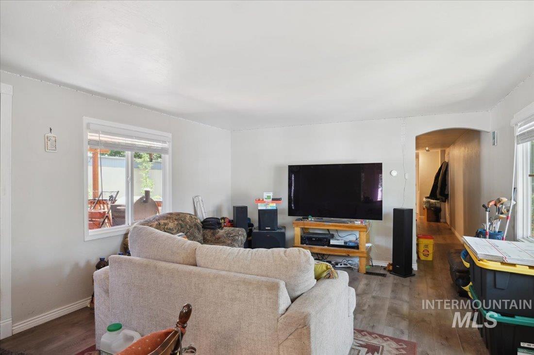 Living area with arched walkways and wood finished floors