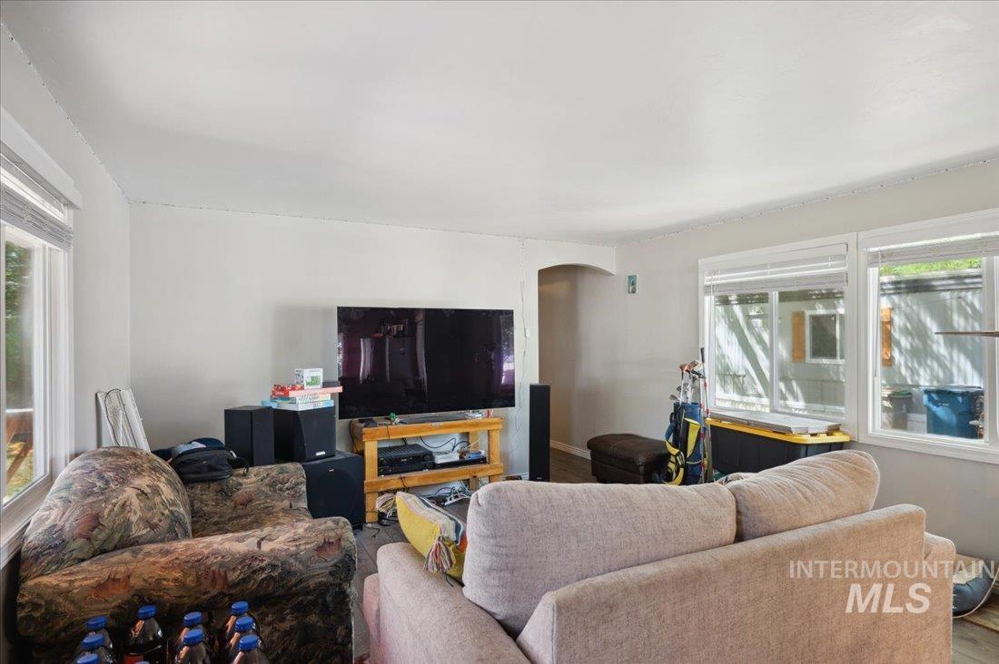 Living area with arched walkways and wood finished floors