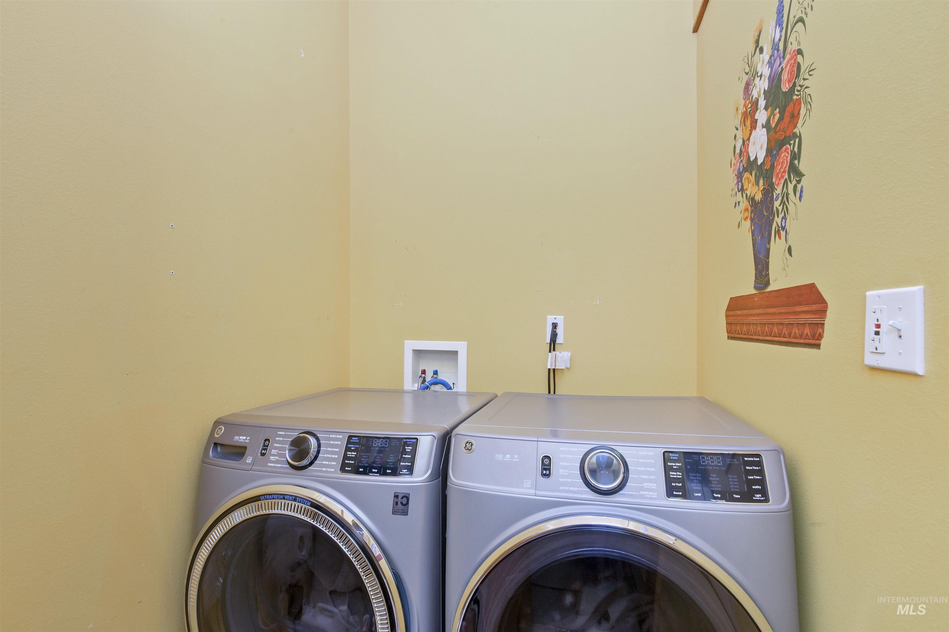 Separate washroom featuring washing machine and clothes dryer