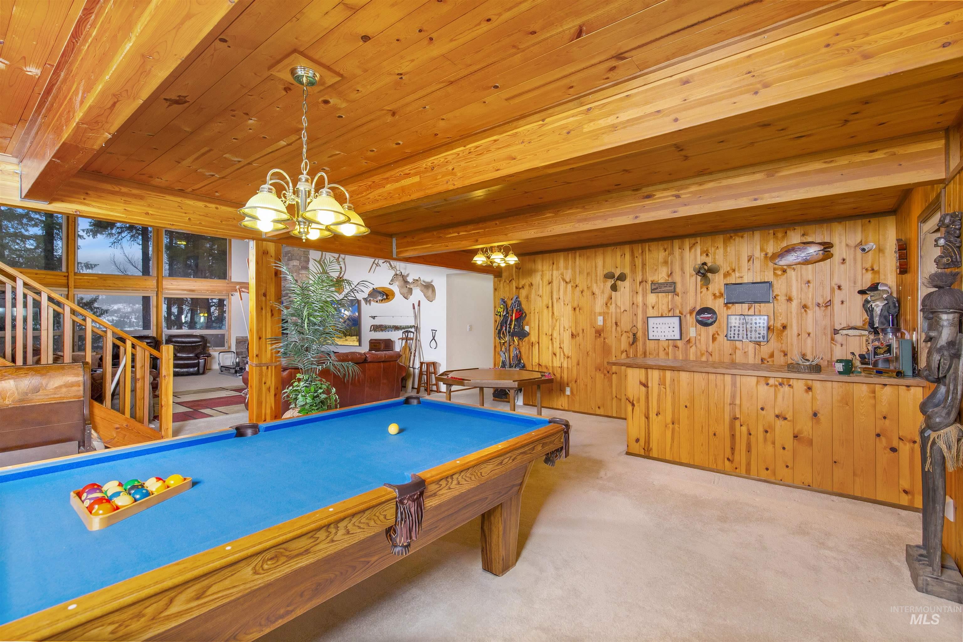 Playroom with carpet floors, wooden walls, a wood ceiling with exposed beams, service bar, and billiards