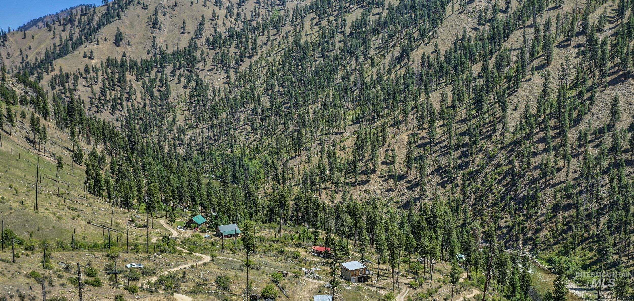 Aerial view of property and surrounding area featuring a forest
