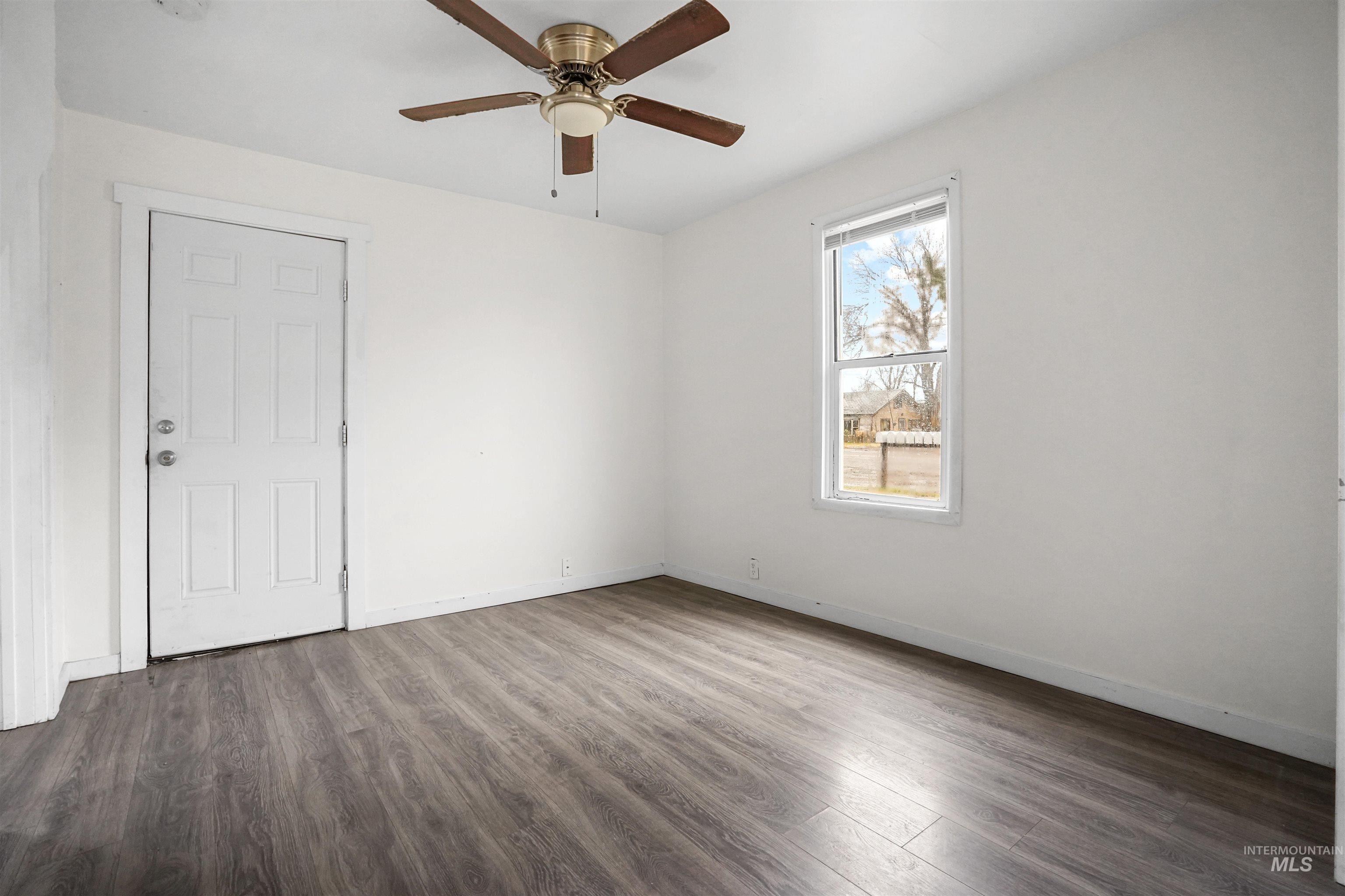 Empty room with wood finished floors and a ceiling fan