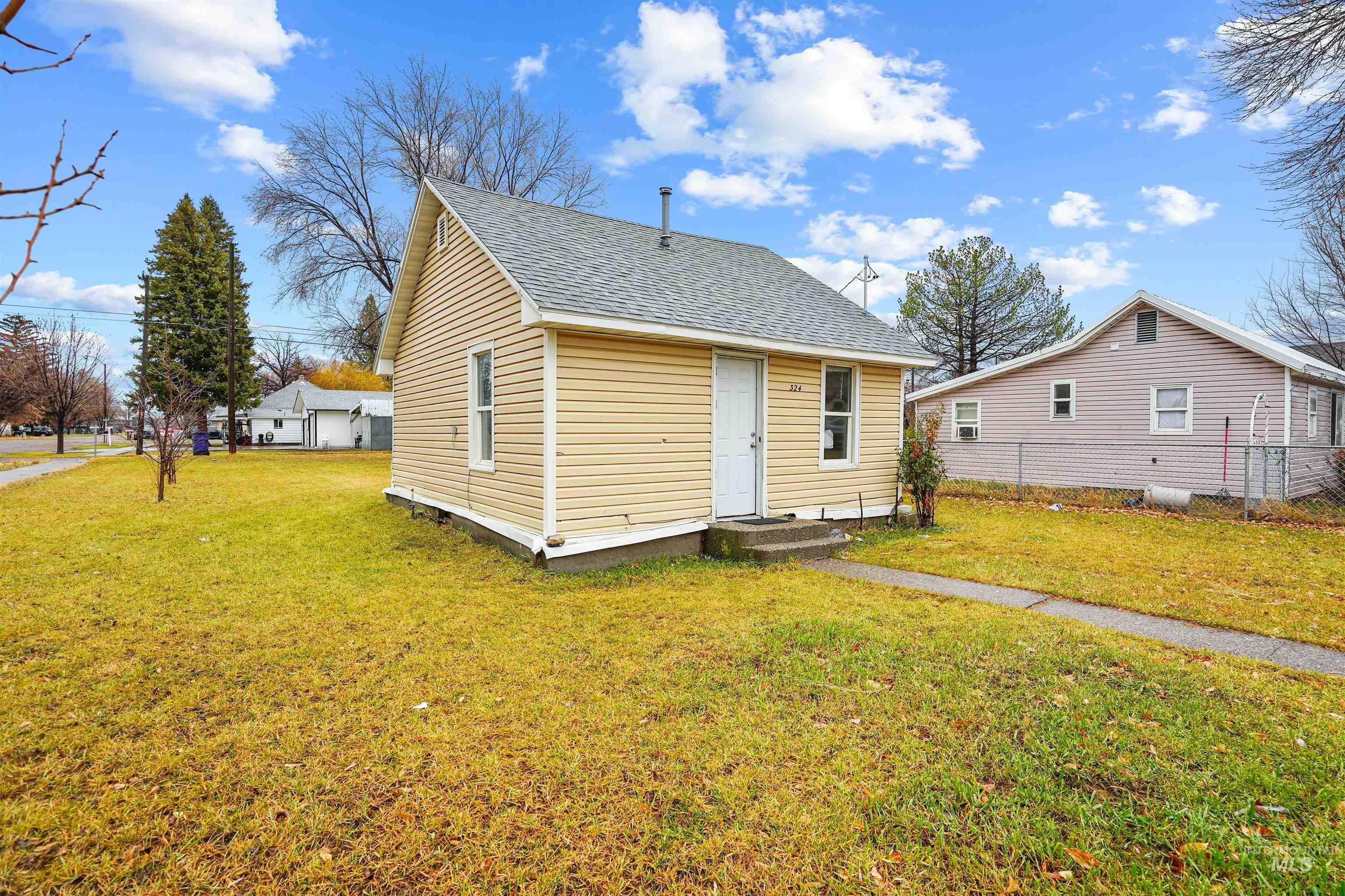 View of front of home with a front lawn and roof with shingles