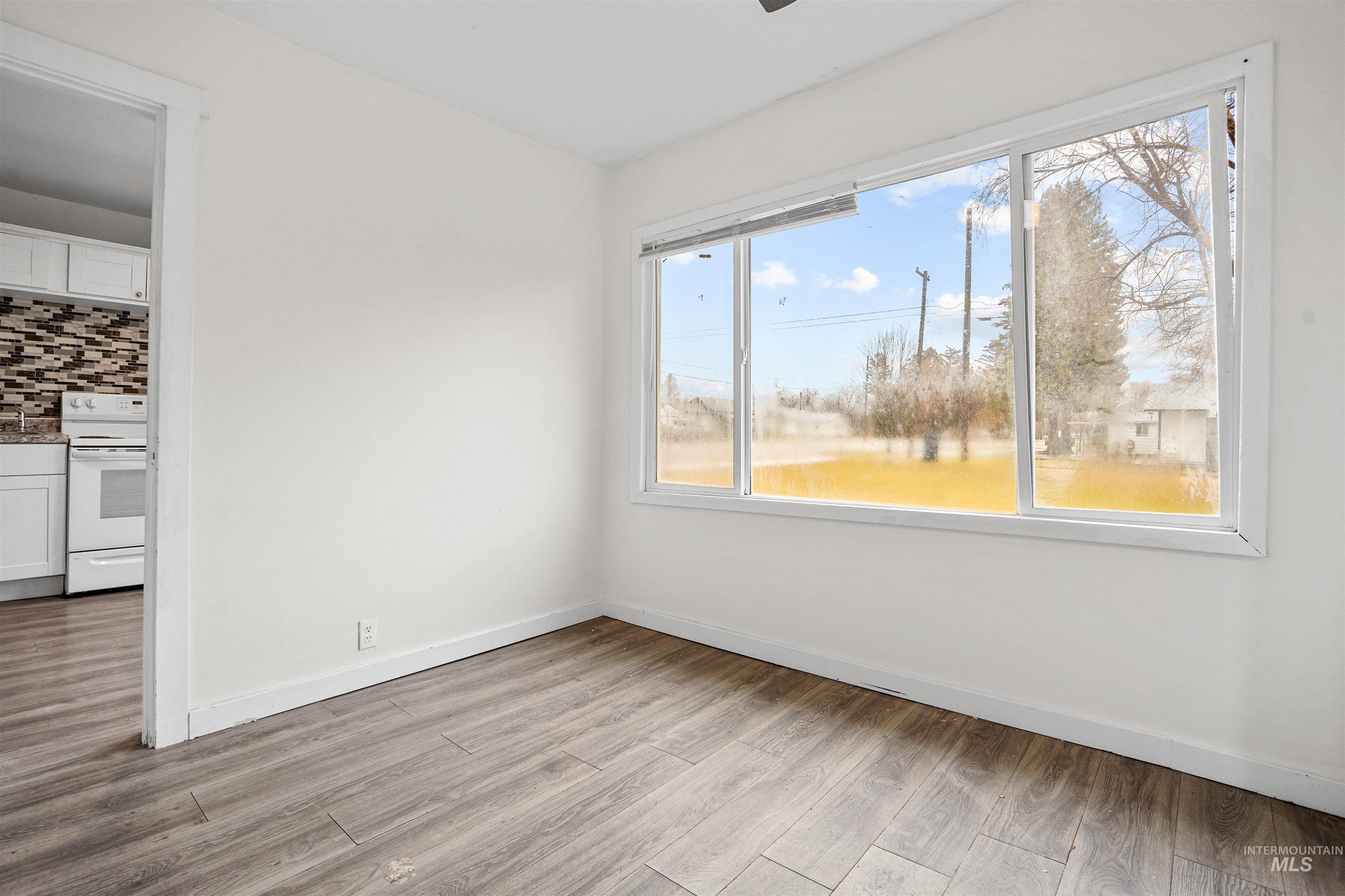 Spare room featuring light wood-style floors and baseboards