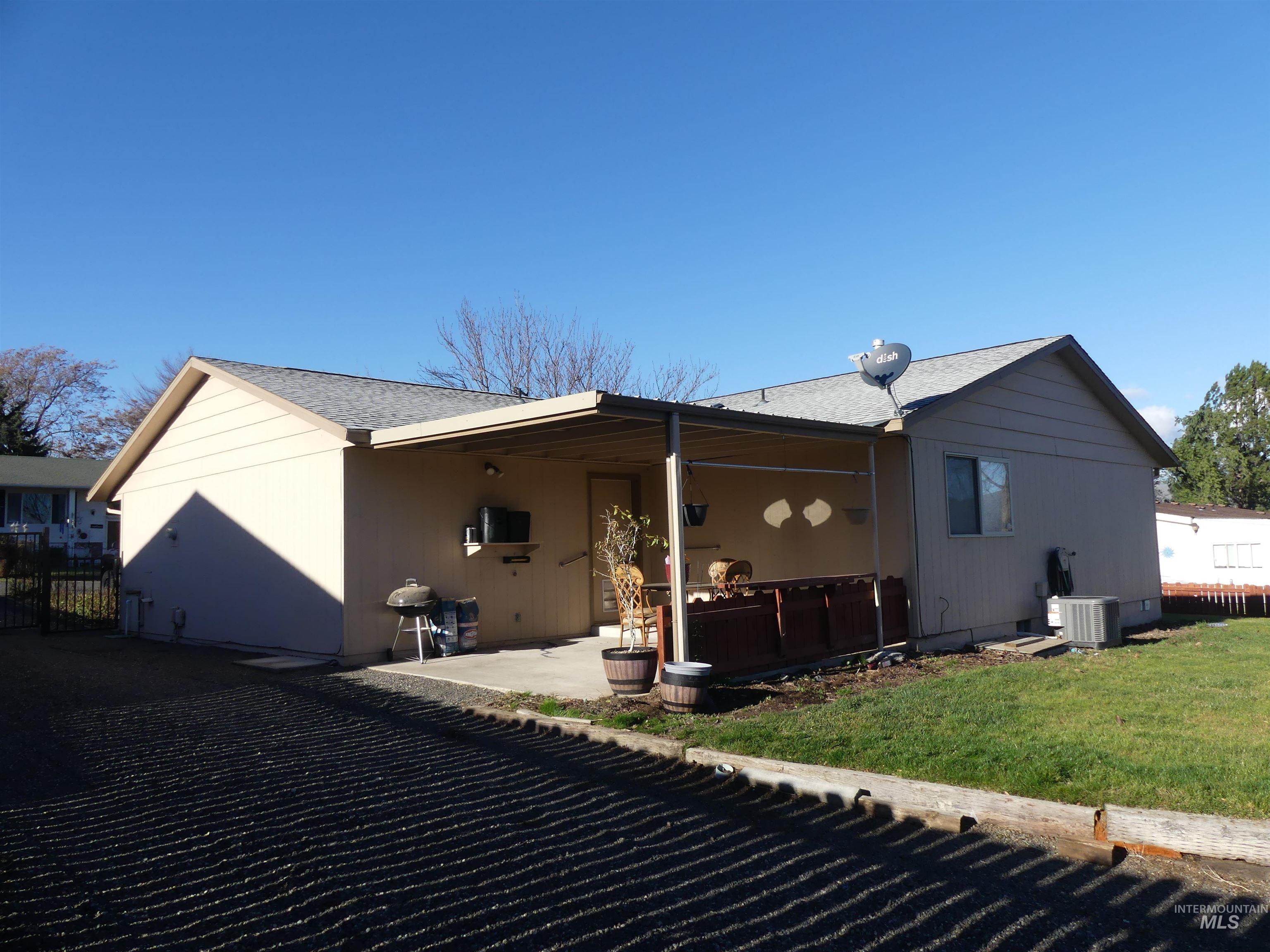 Back of property with a patio and roof with shingles