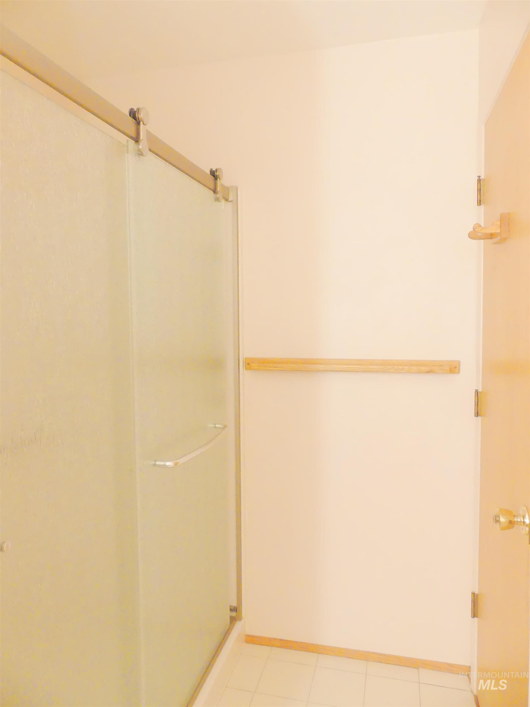 Full bathroom with a stall shower and light tile patterned floors