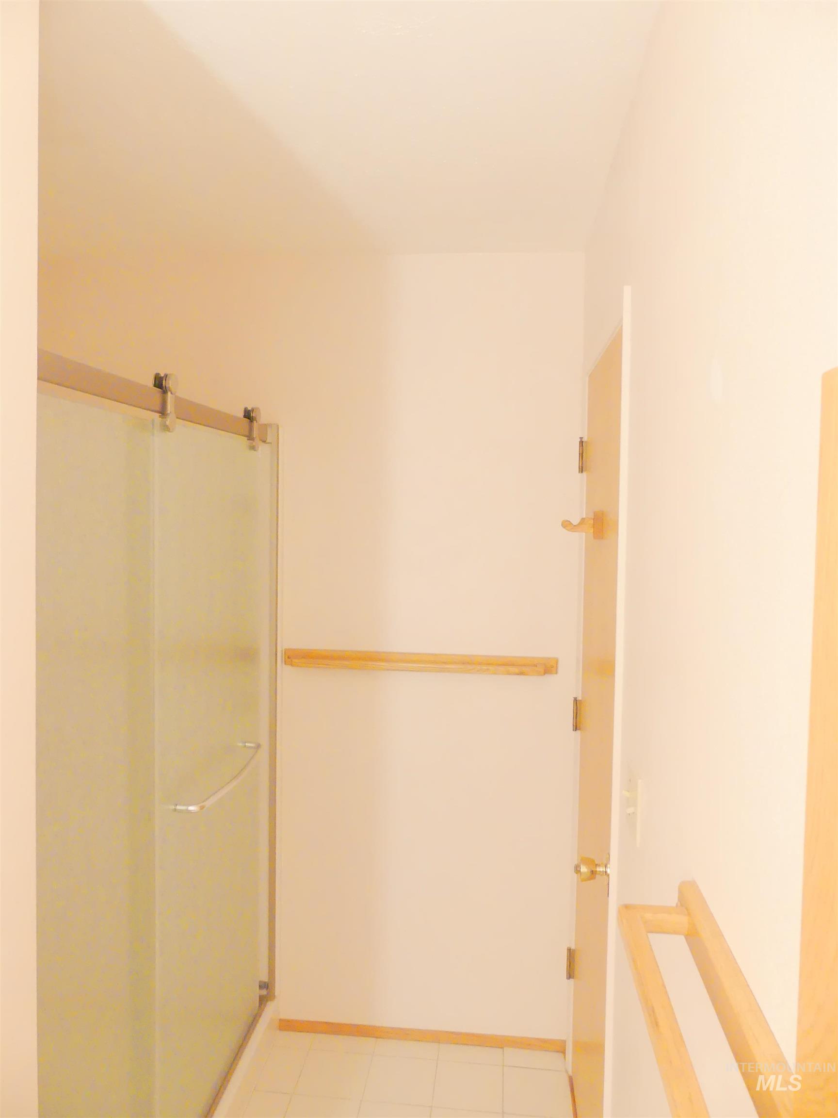 Corridor featuring light tile patterned floors and baseboards