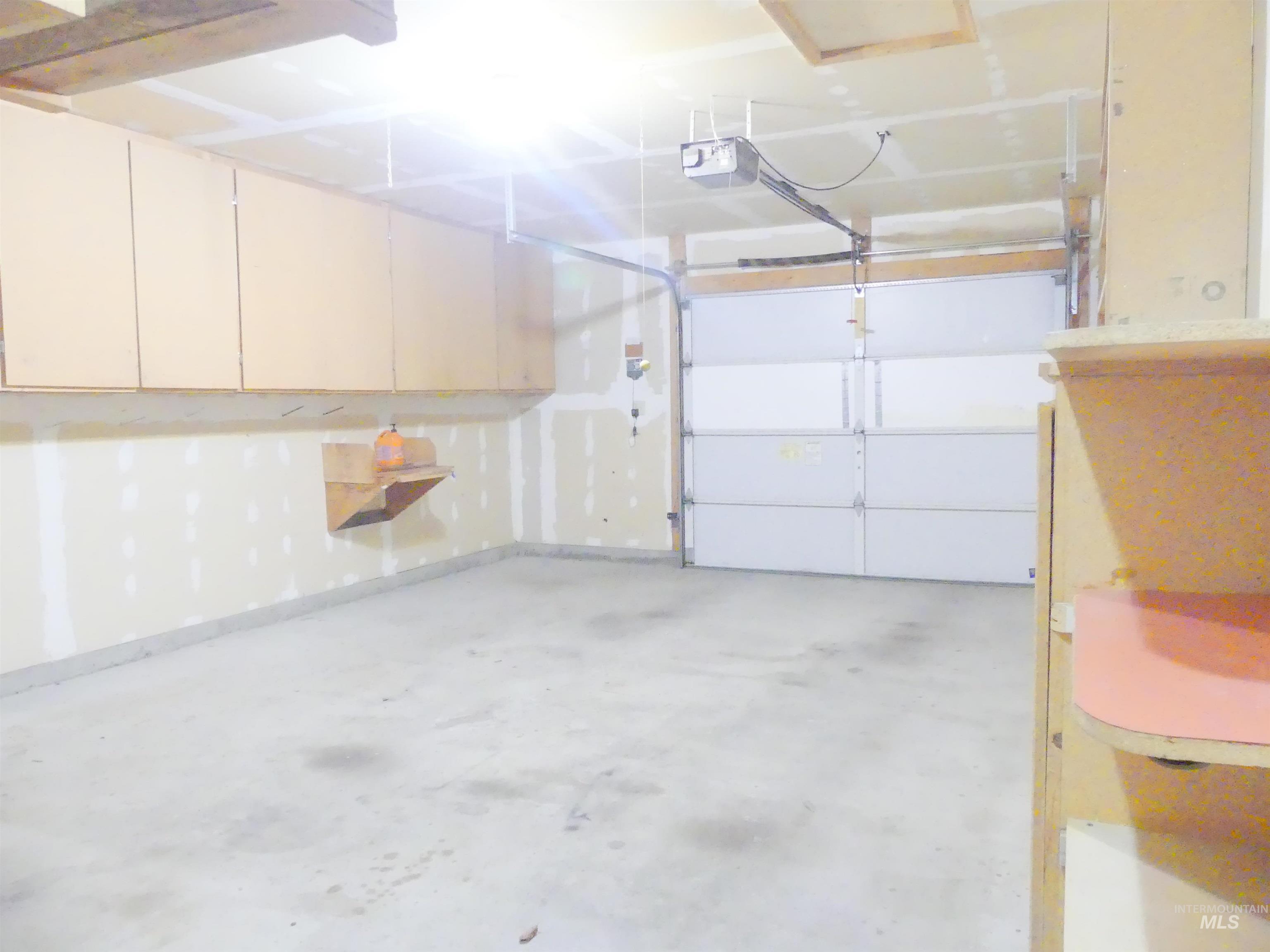 Garage with a garage door opener and baseboards
