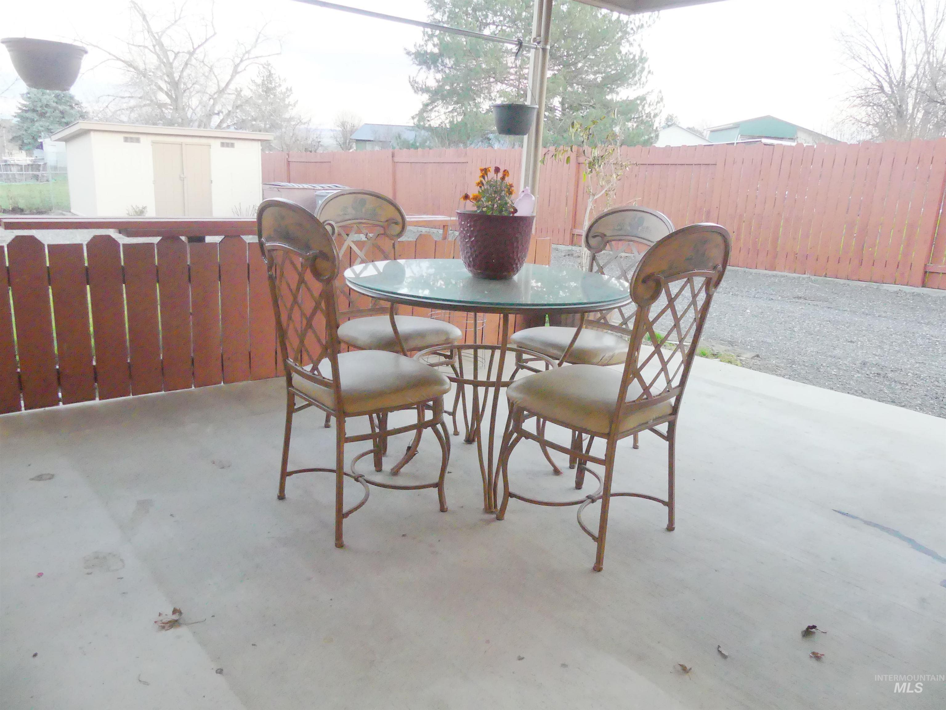 Fenced backyard featuring a storage shed and outdoor dining area