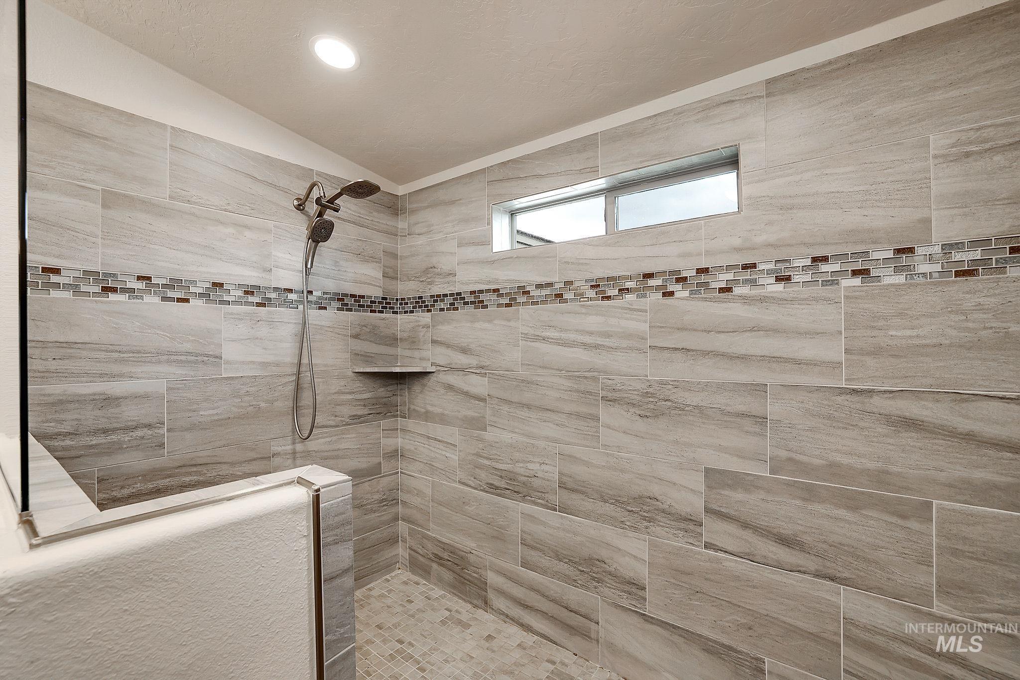 Bathroom featuring a walk in shower, recessed lighting, and lofted ceiling