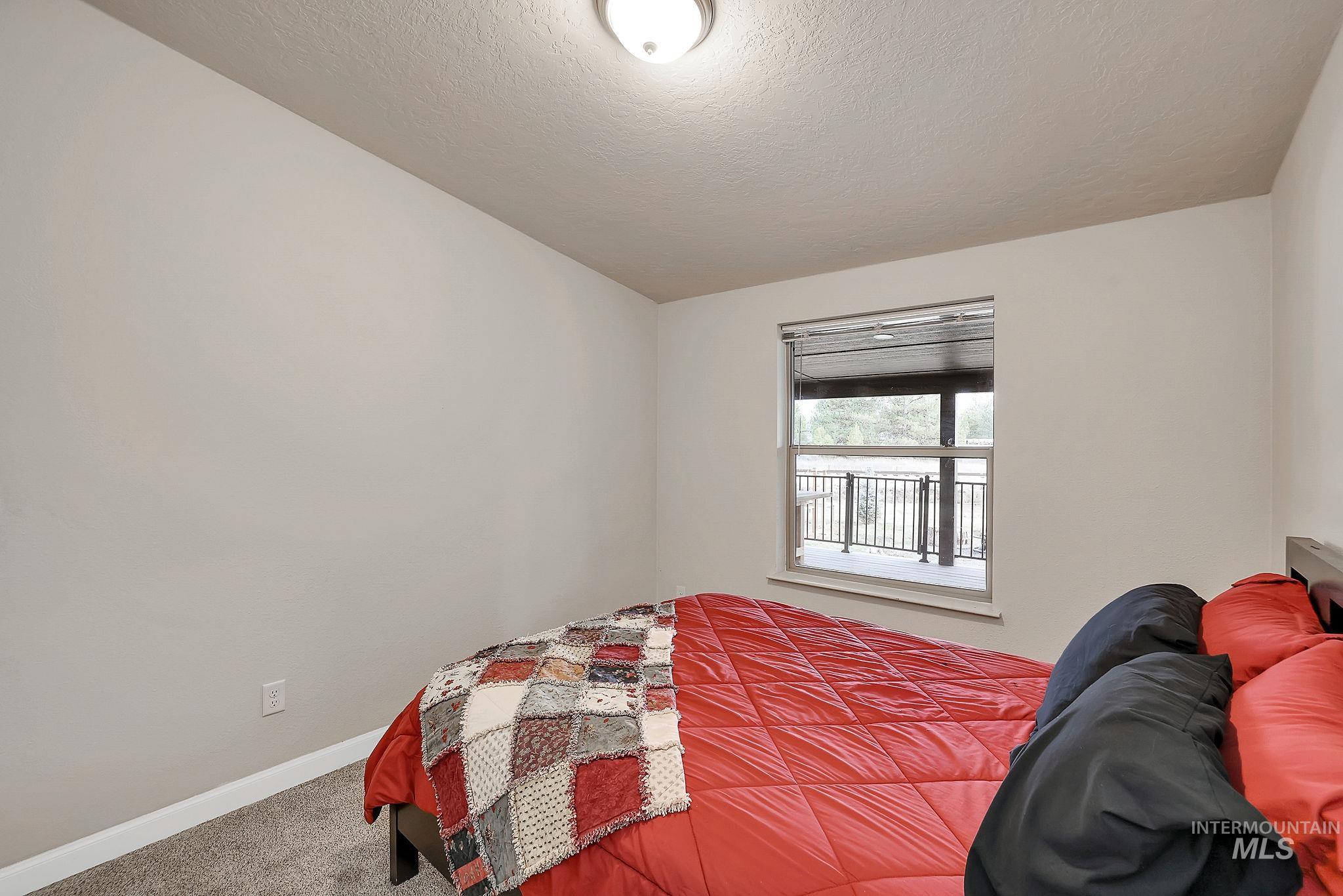 Bedroom with carpet floors and a textured ceiling