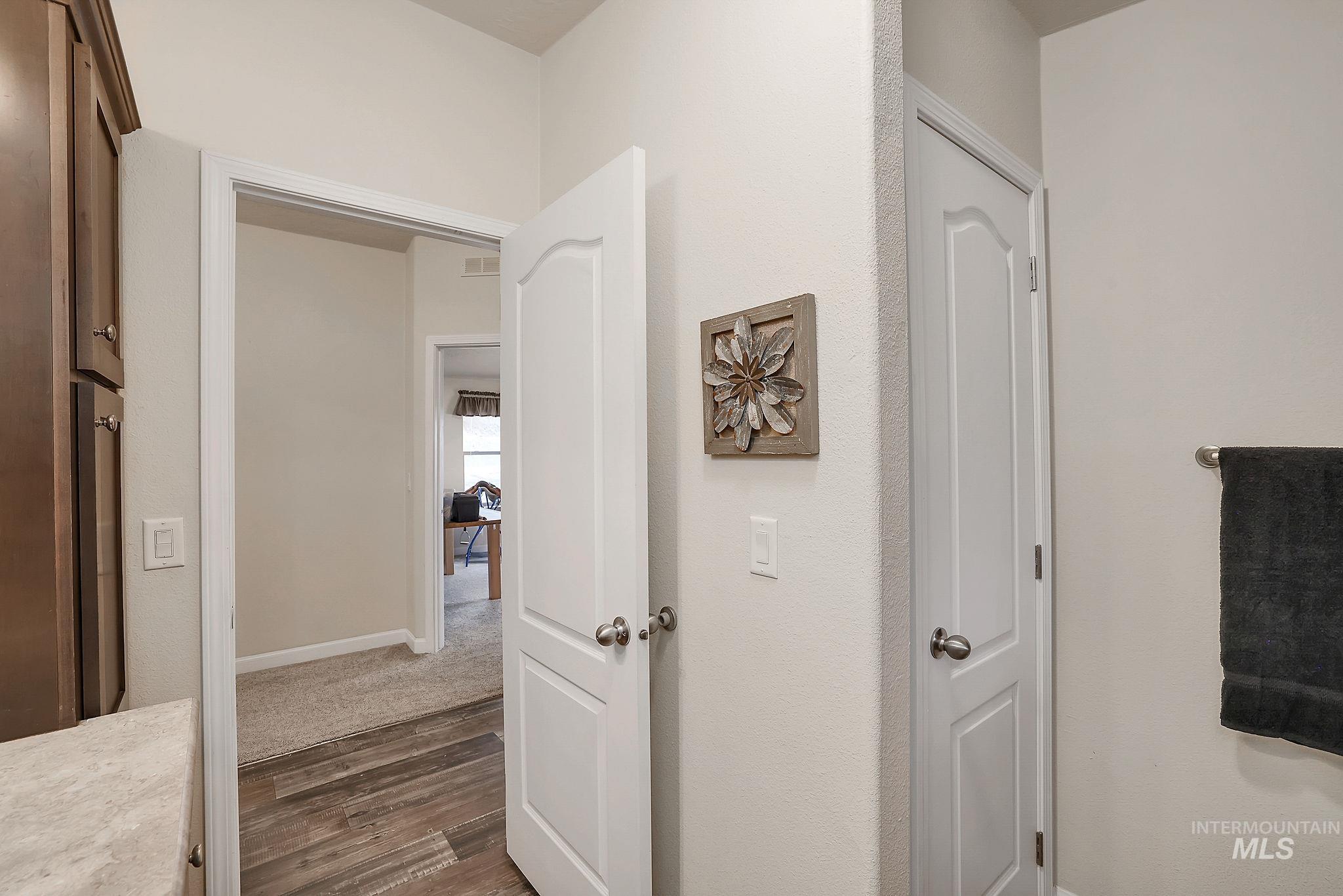 Hallway featuring dark wood-style floors and baseboards