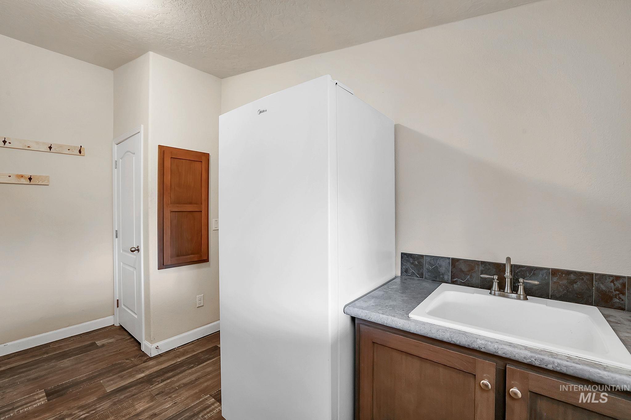 Bathroom featuring vanity, a textured ceiling, and dark wood-style floors