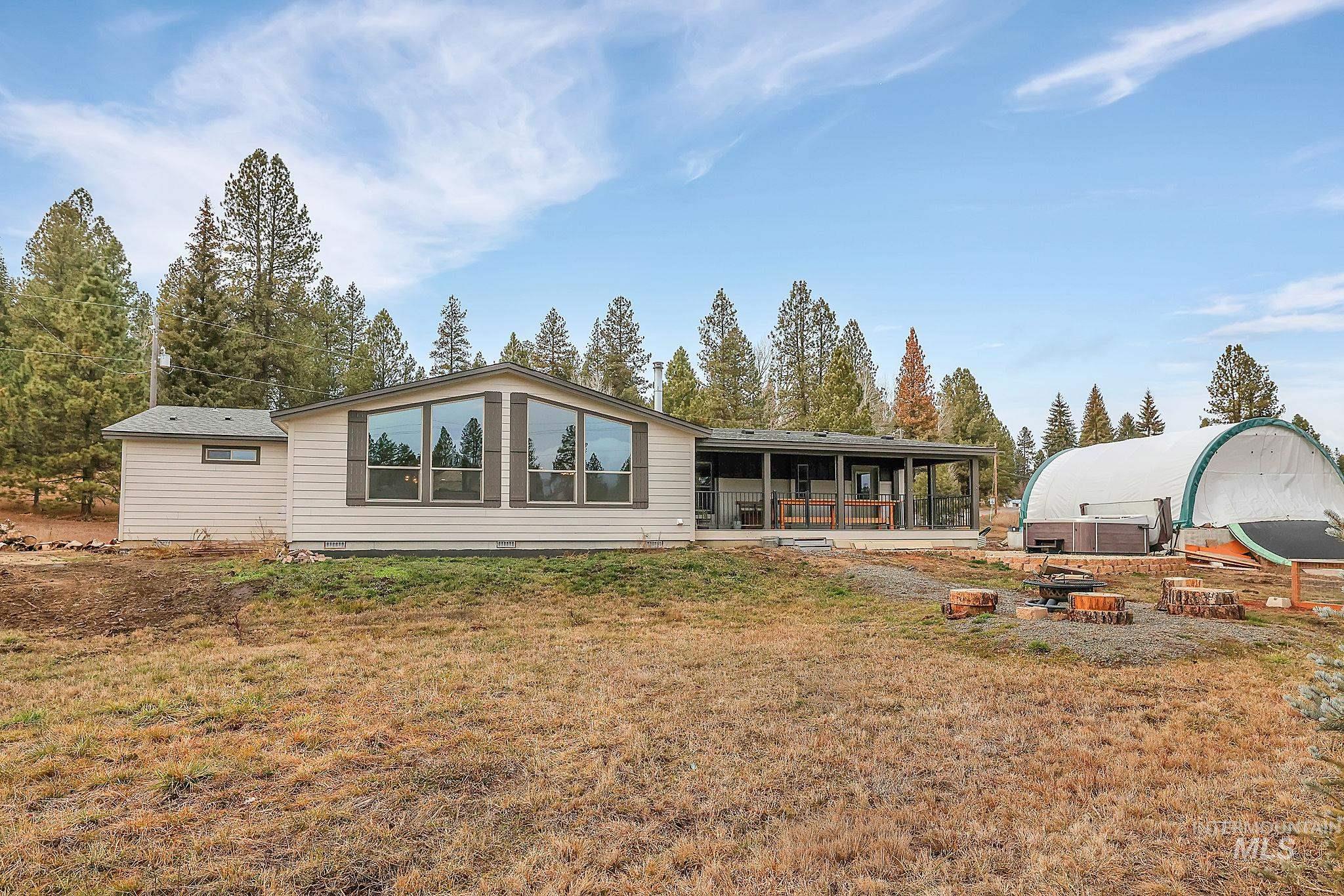 Rear view of house with a sunroom, a lawn, and a patio