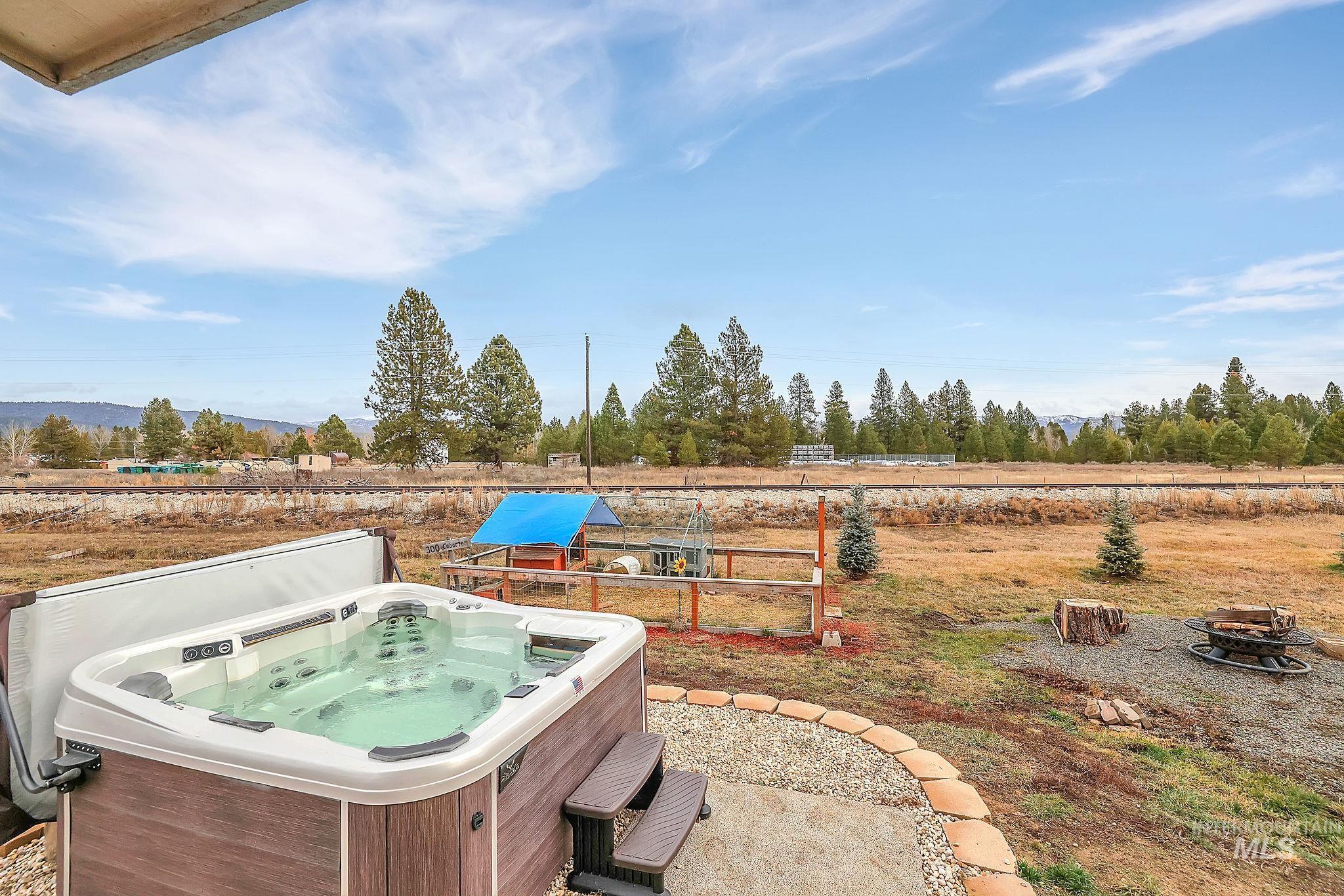 View of yard with a hot tub, an outdoor fire pit, and a patio