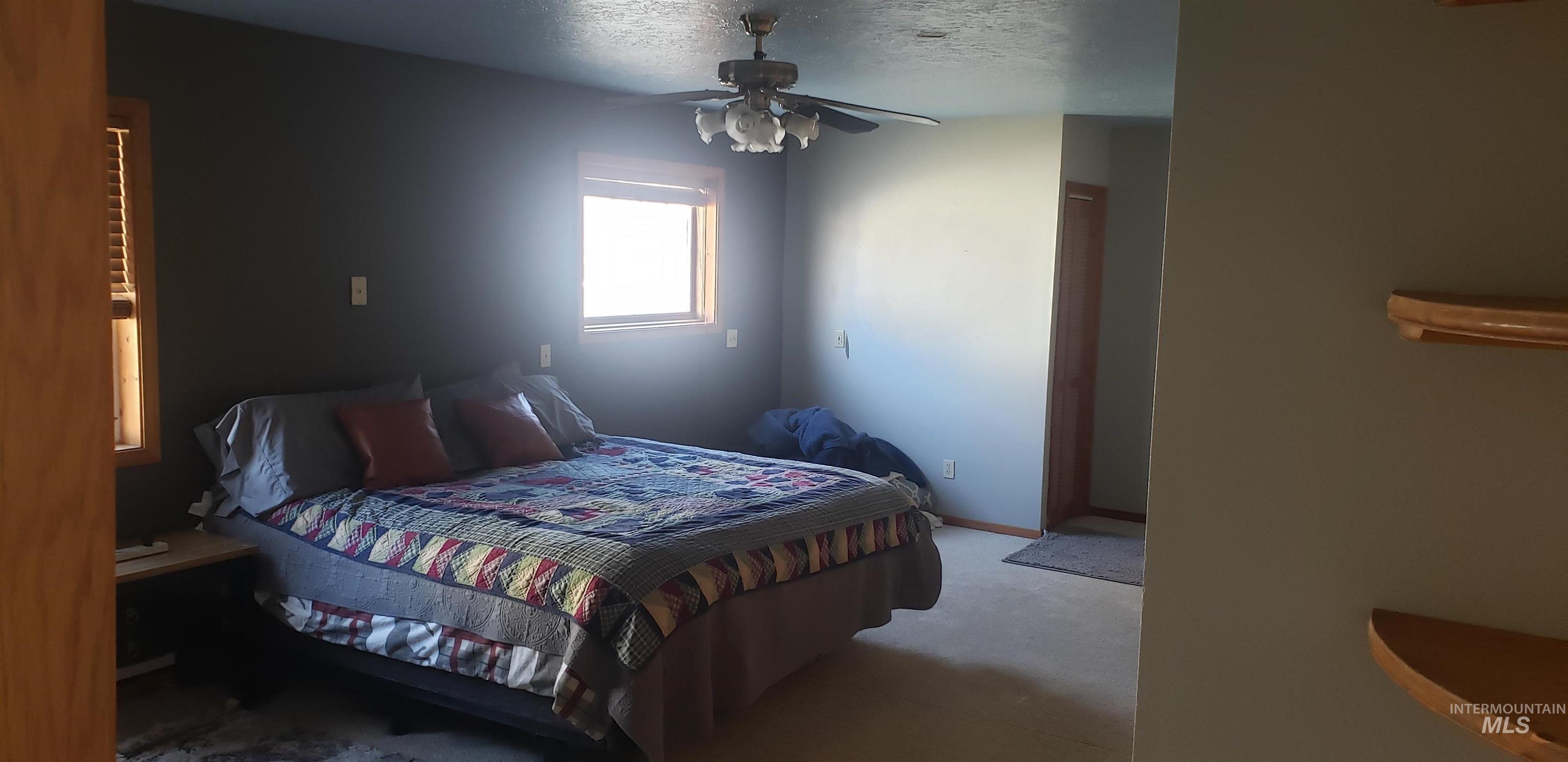 Bedroom with a textured ceiling and a ceiling fan