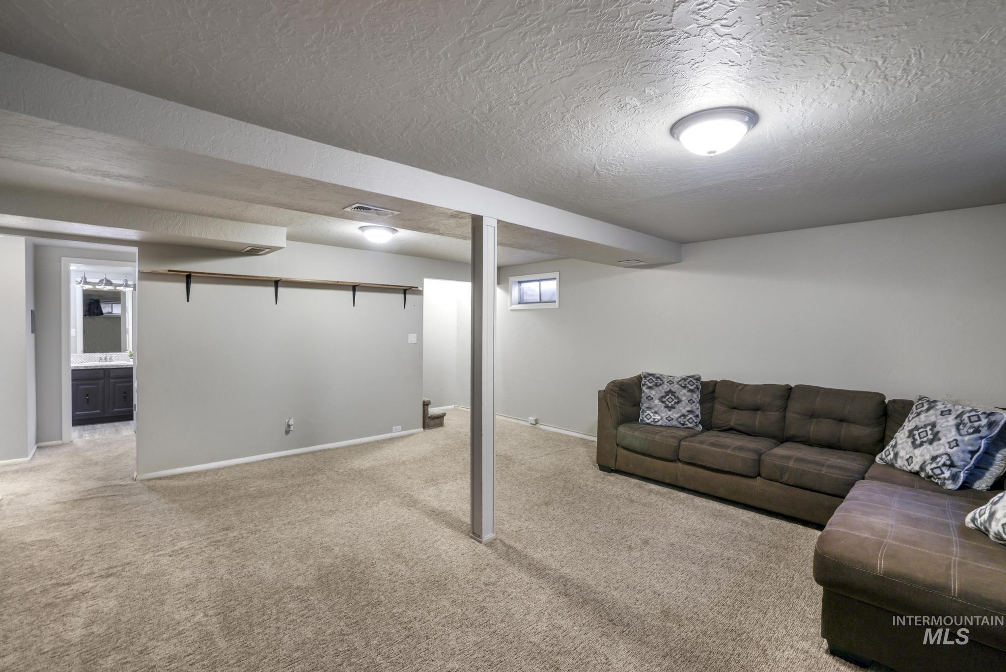 Living room with a textured ceiling and light colored carpet