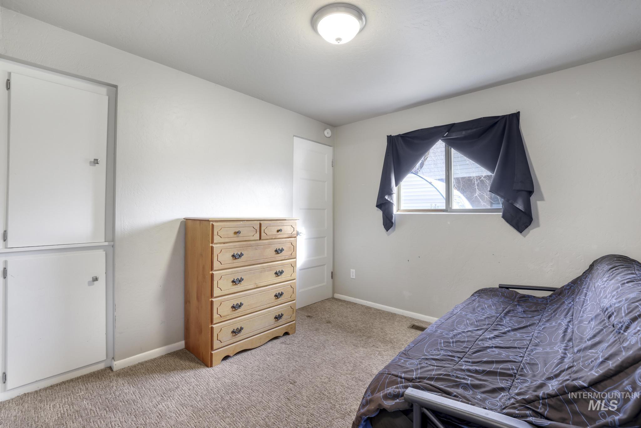 Bedroom featuring light colored carpet and baseboards