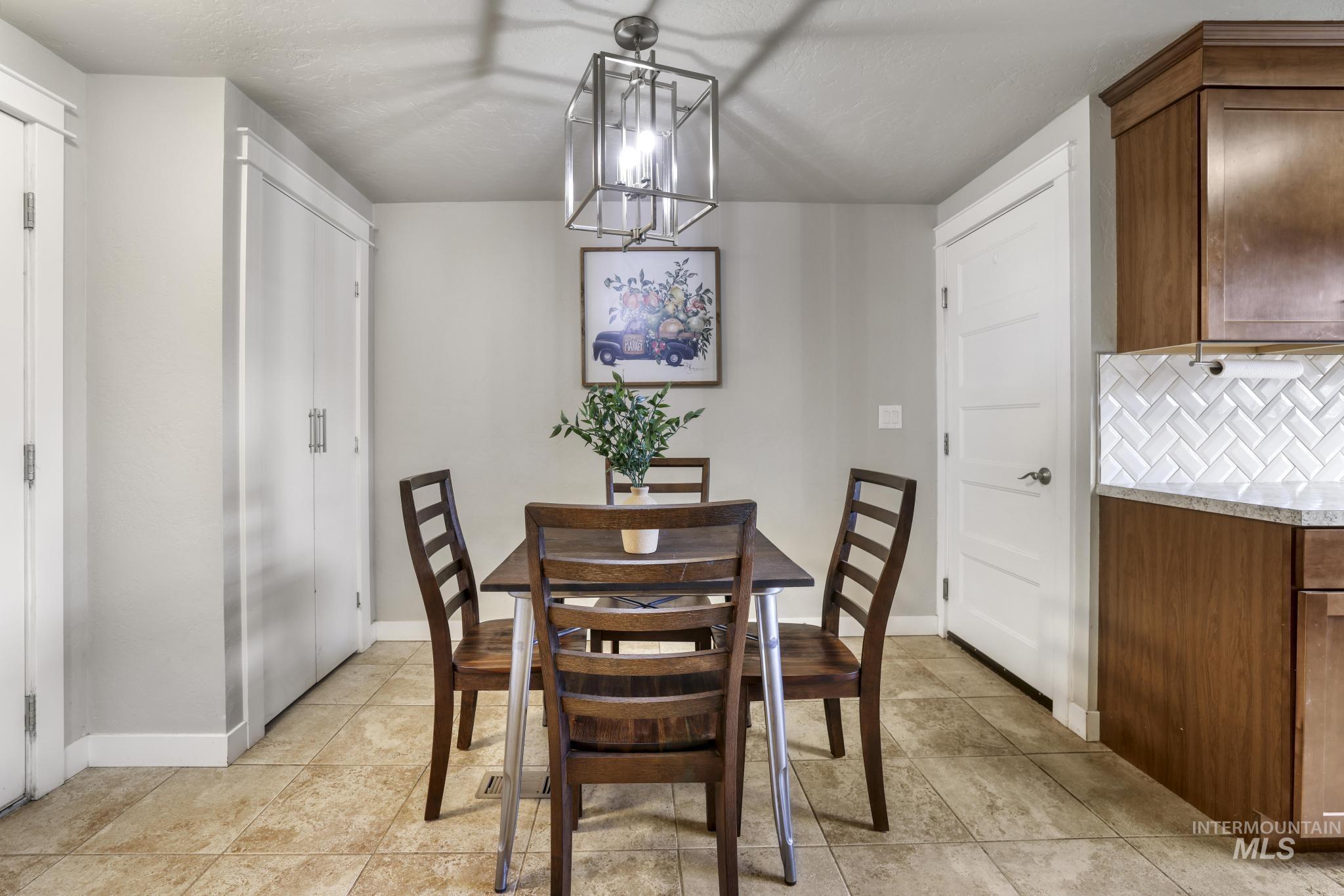 Dining area with a chandelier and light tile patterned flooring