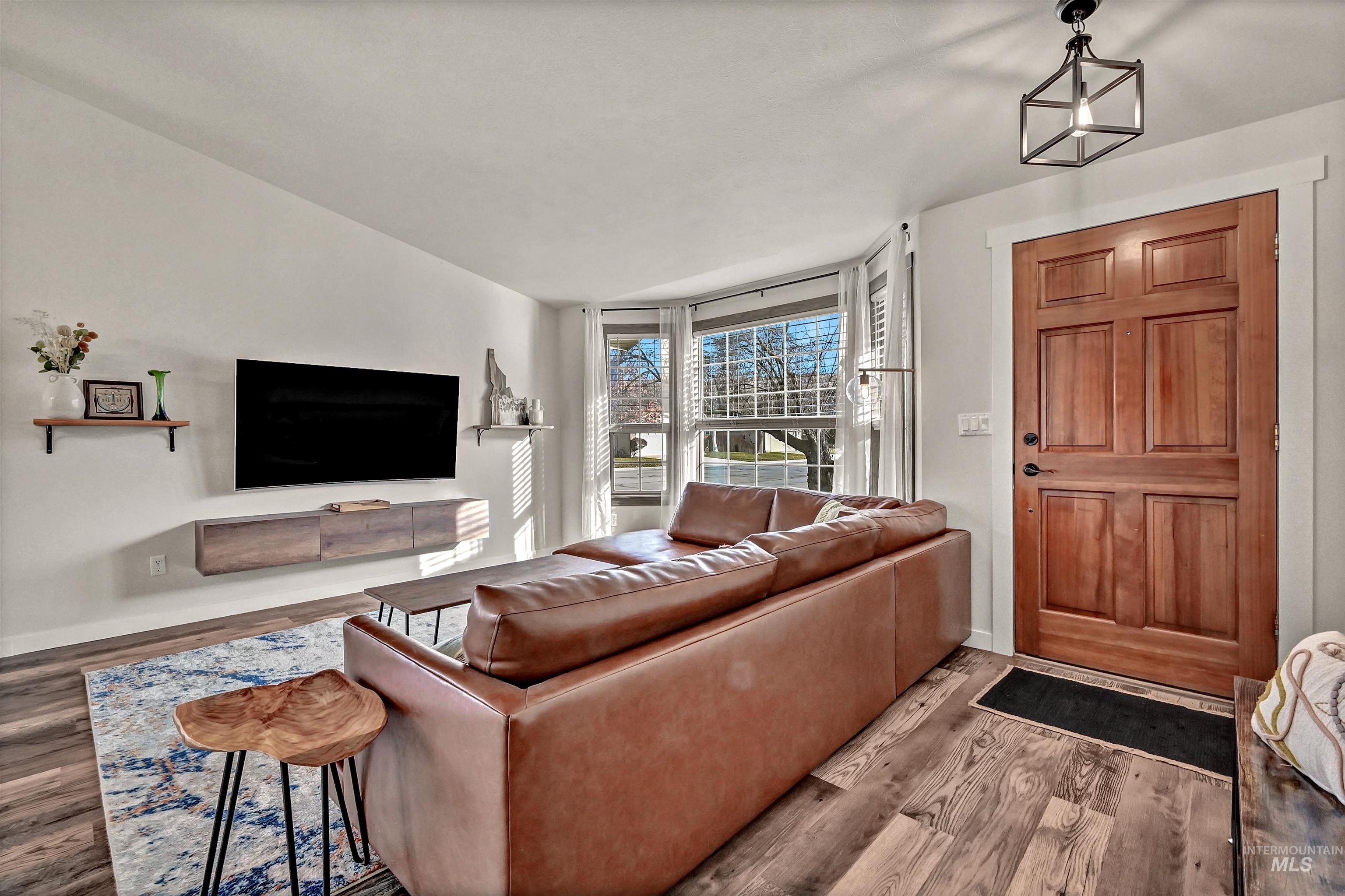 Living area with wood finished floors and vaulted ceiling