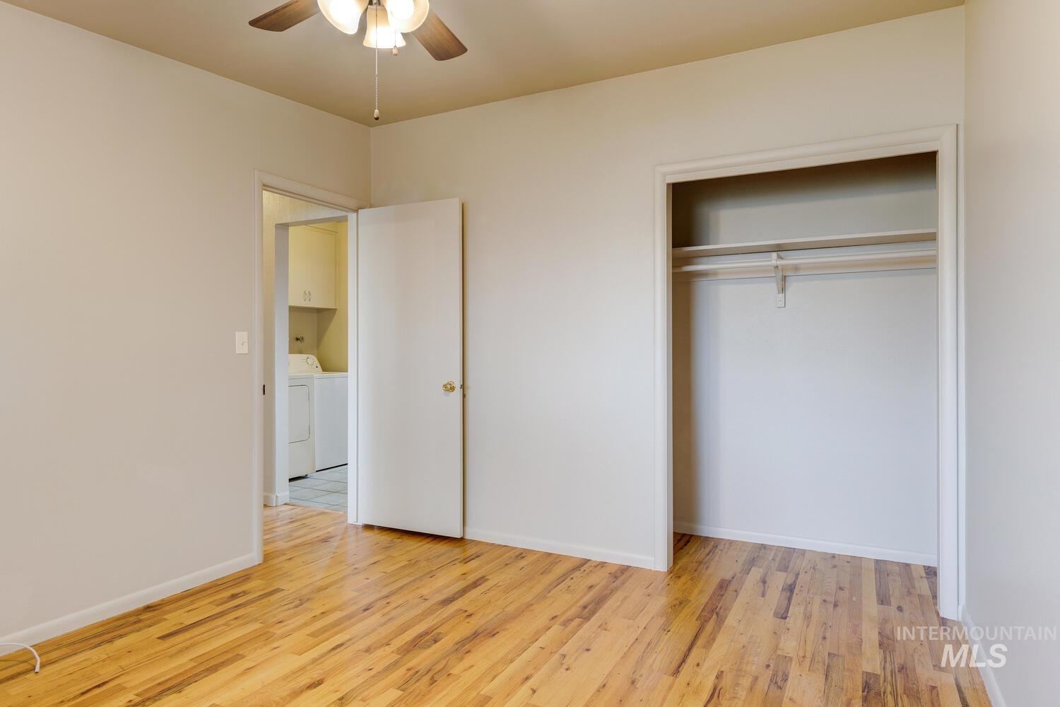 Unfurnished bedroom with light wood-style flooring, a ceiling fan, and a closet