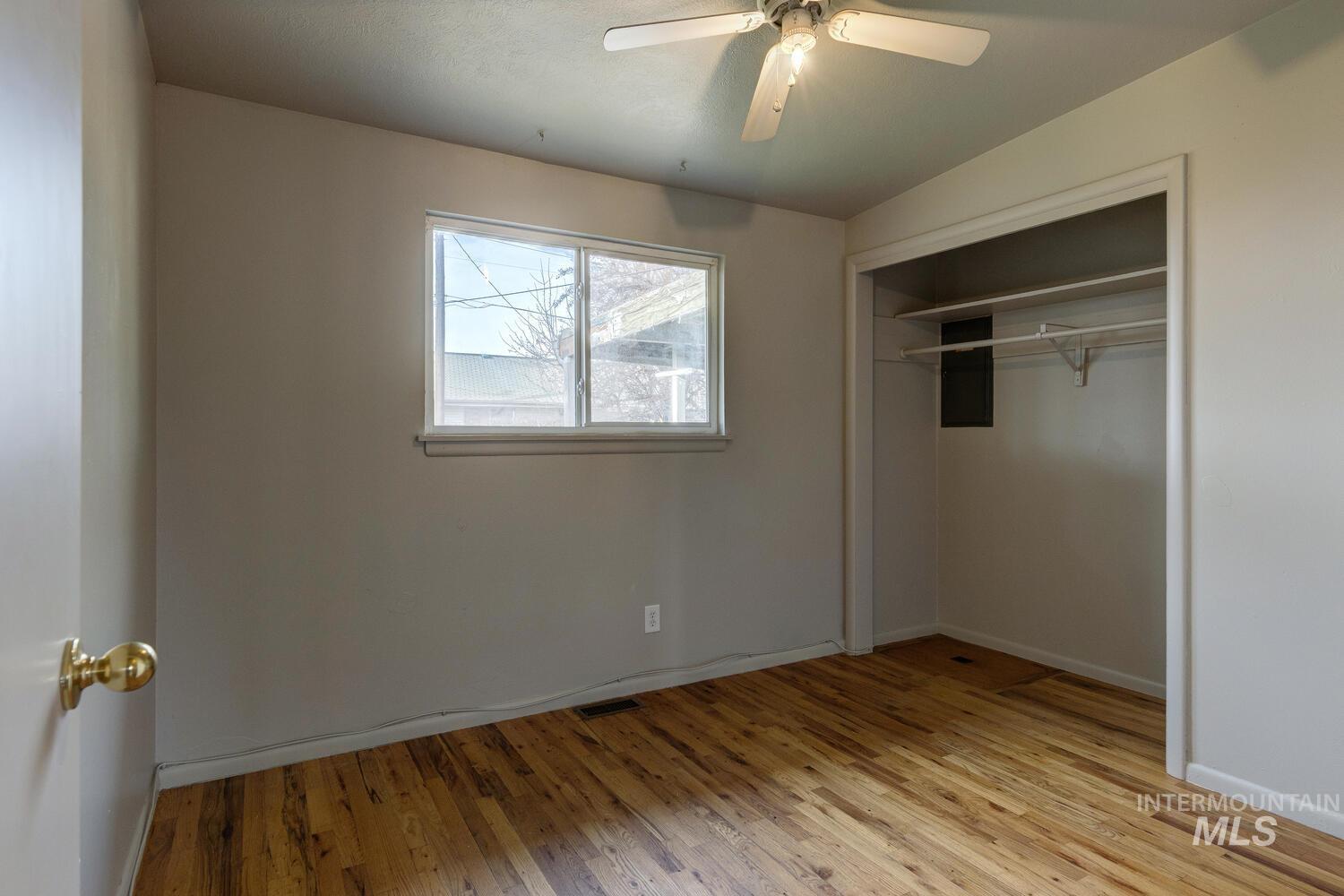 Unfurnished bedroom featuring light wood-style flooring, a ceiling fan, and a closet
