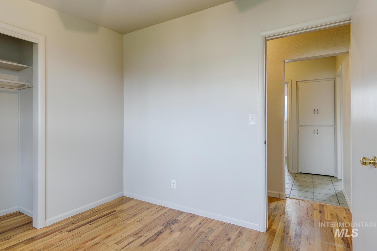 Unfurnished bedroom with light wood-style flooring and a closet