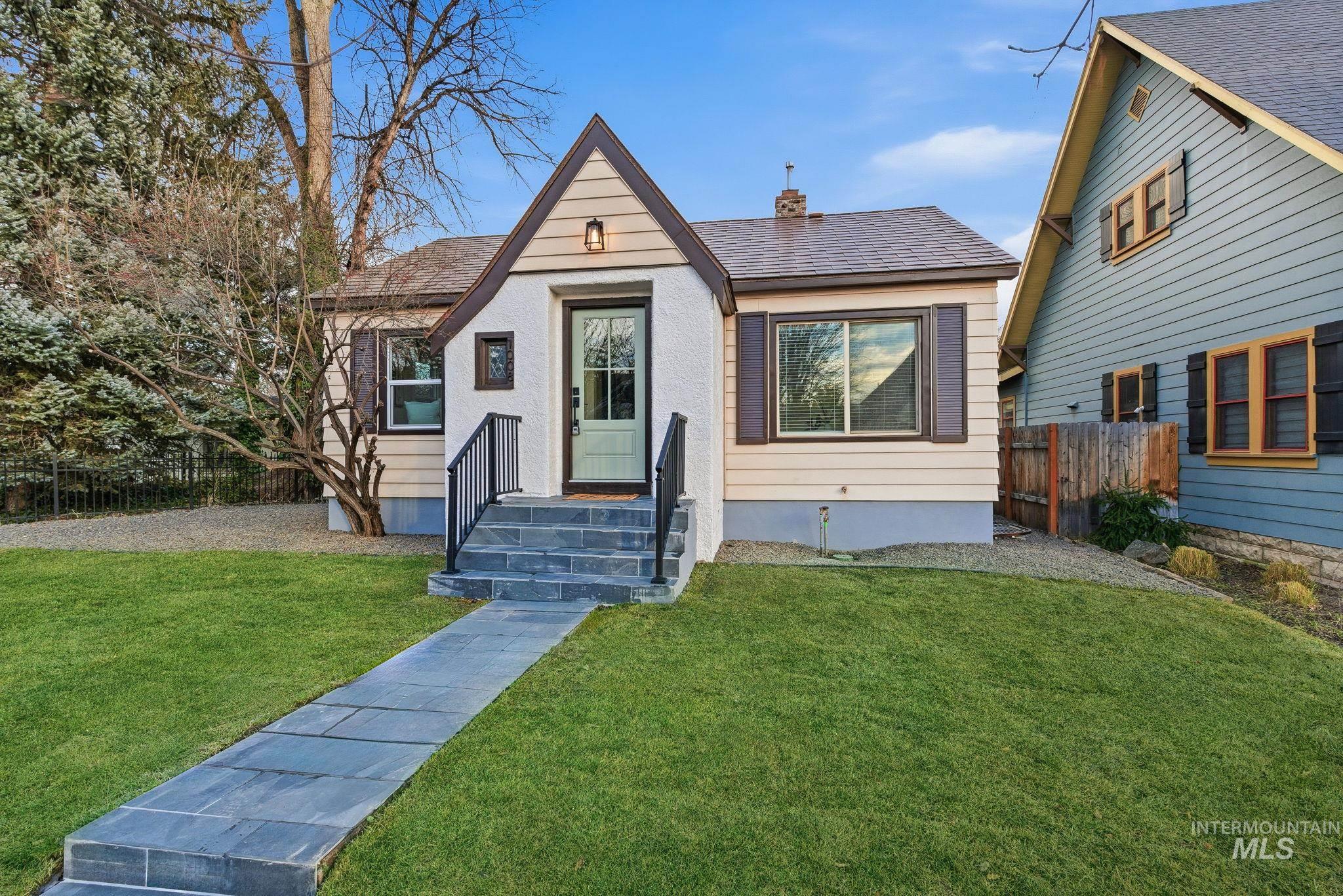 View of front of home with a chimney and roof with shingles