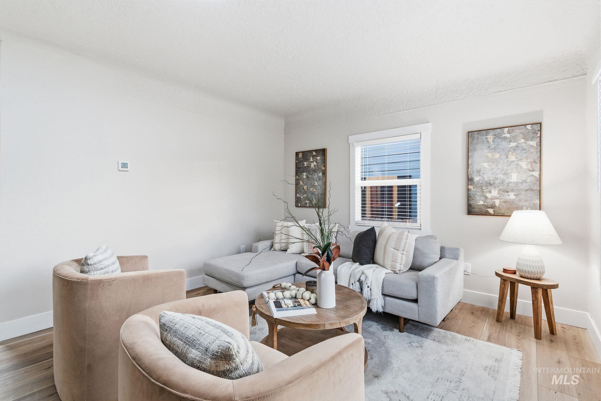Living area featuring wood finished floors and a textured ceiling