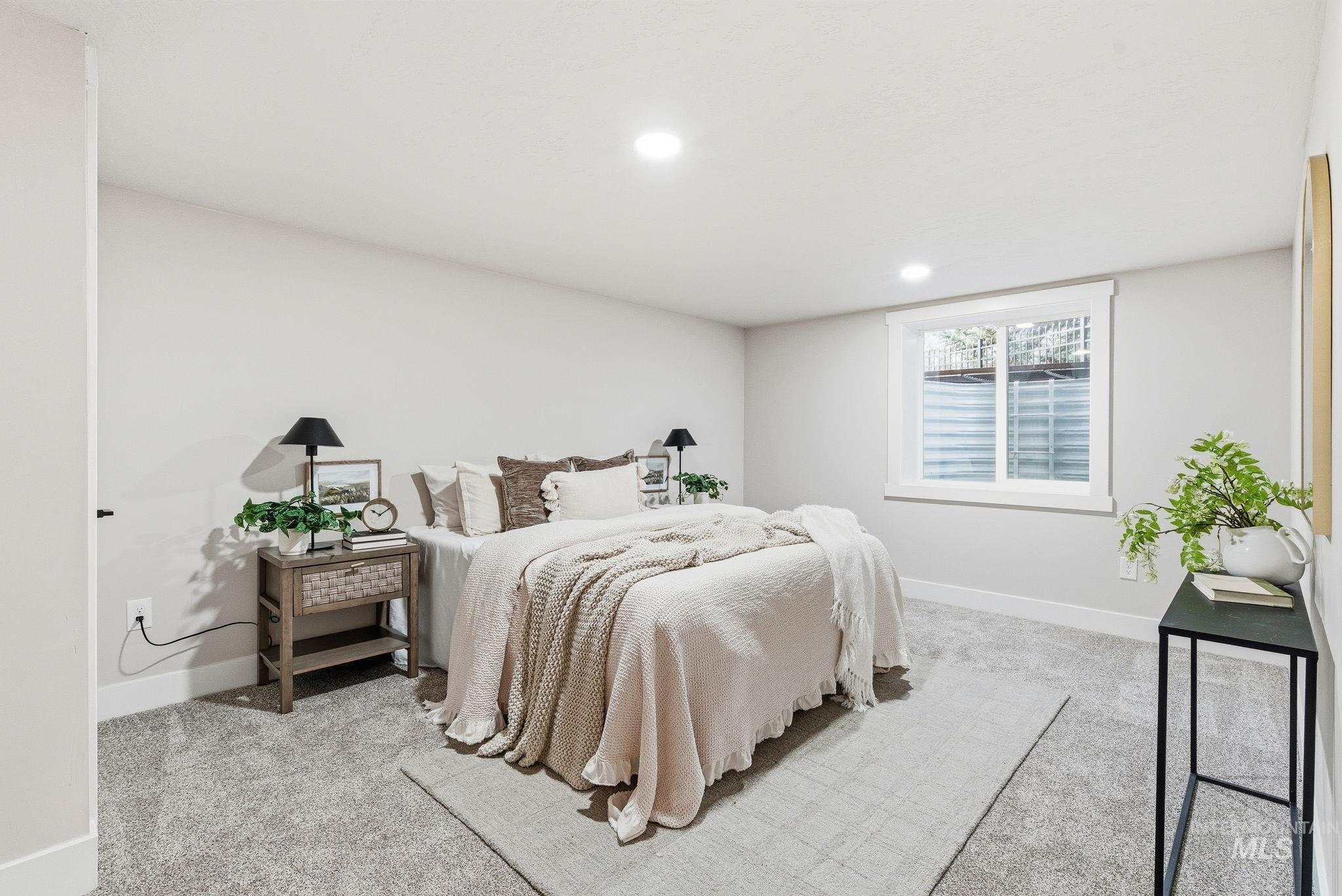 Bedroom with light colored carpet and recessed lighting