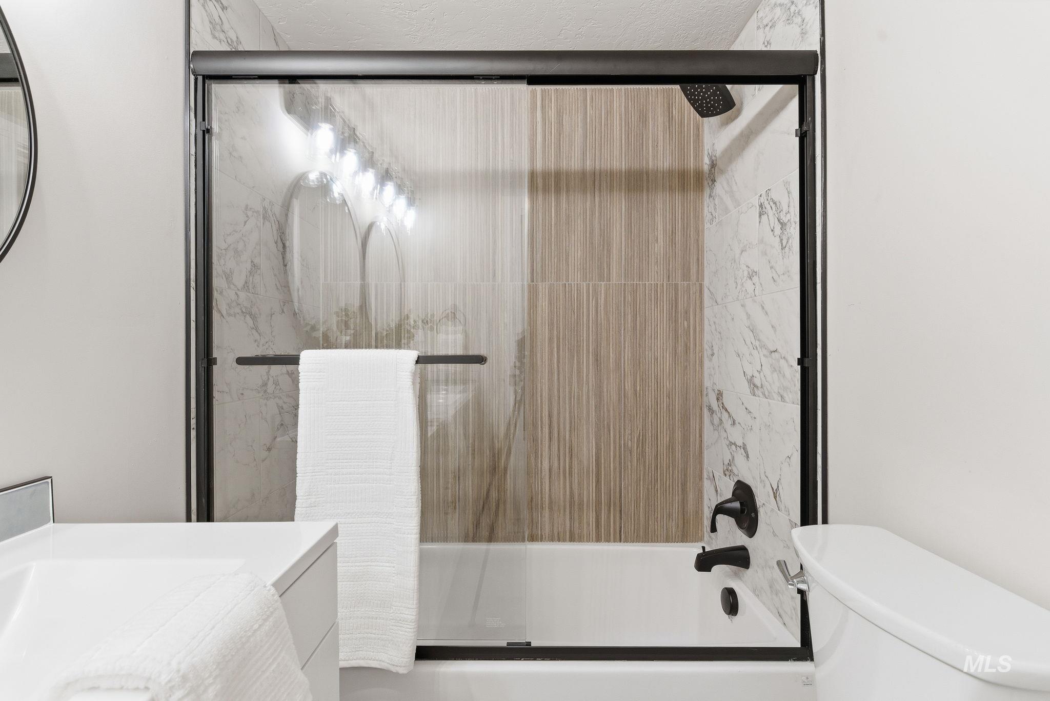 Full bath with enclosed tub / shower combo and vanity