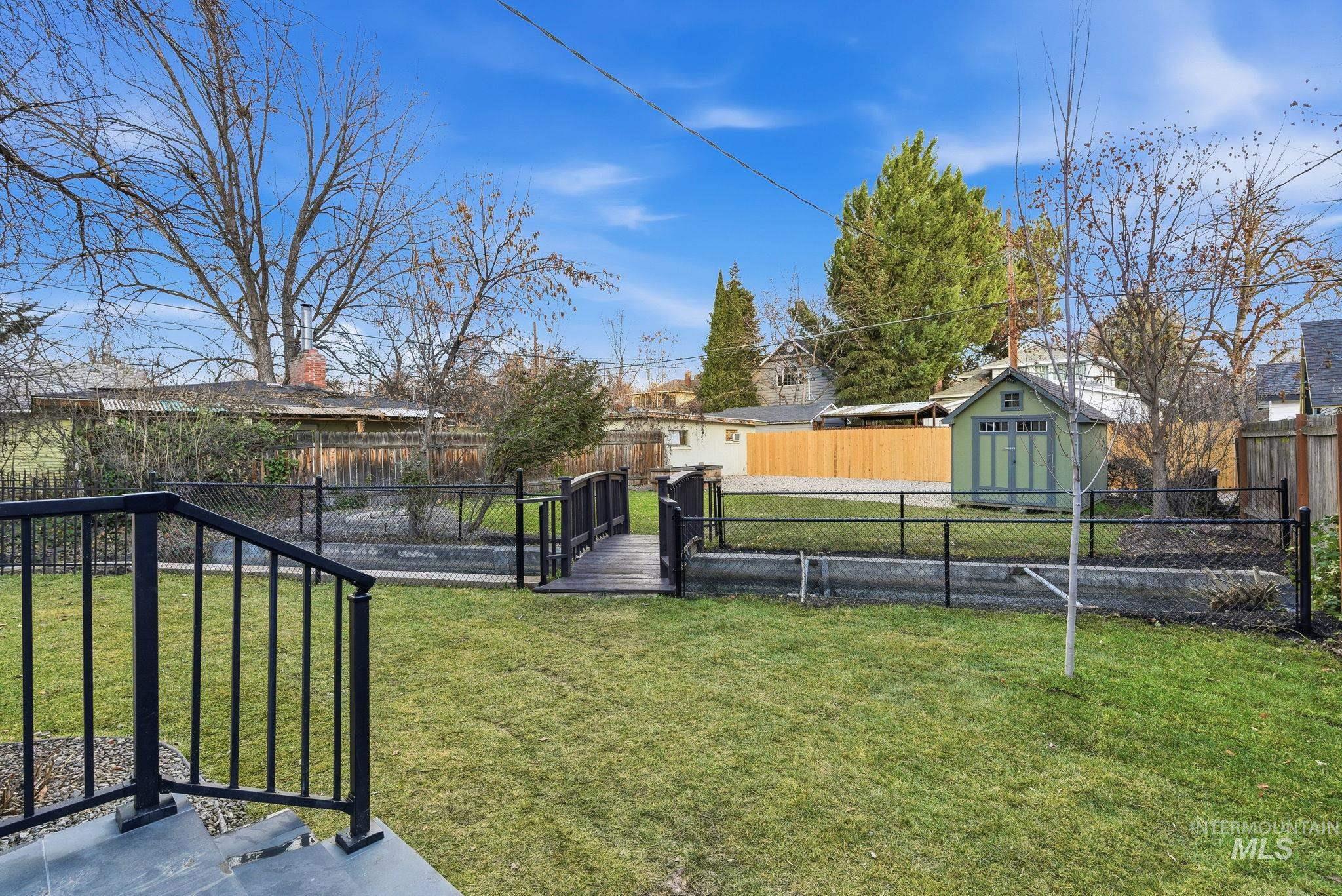 Fenced backyard featuring a storage shed