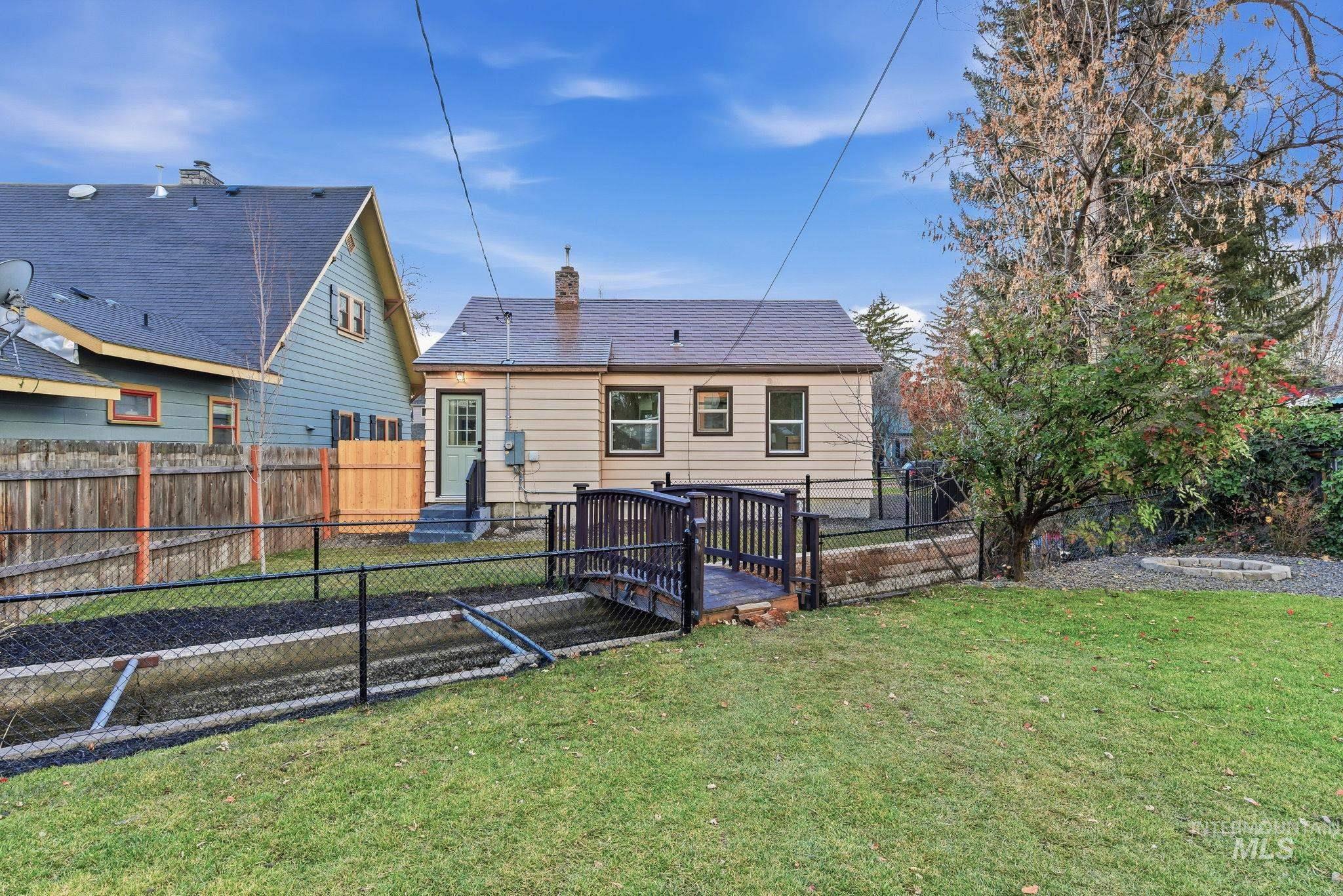 Back of property with a deck, a fenced backyard, and a chimney