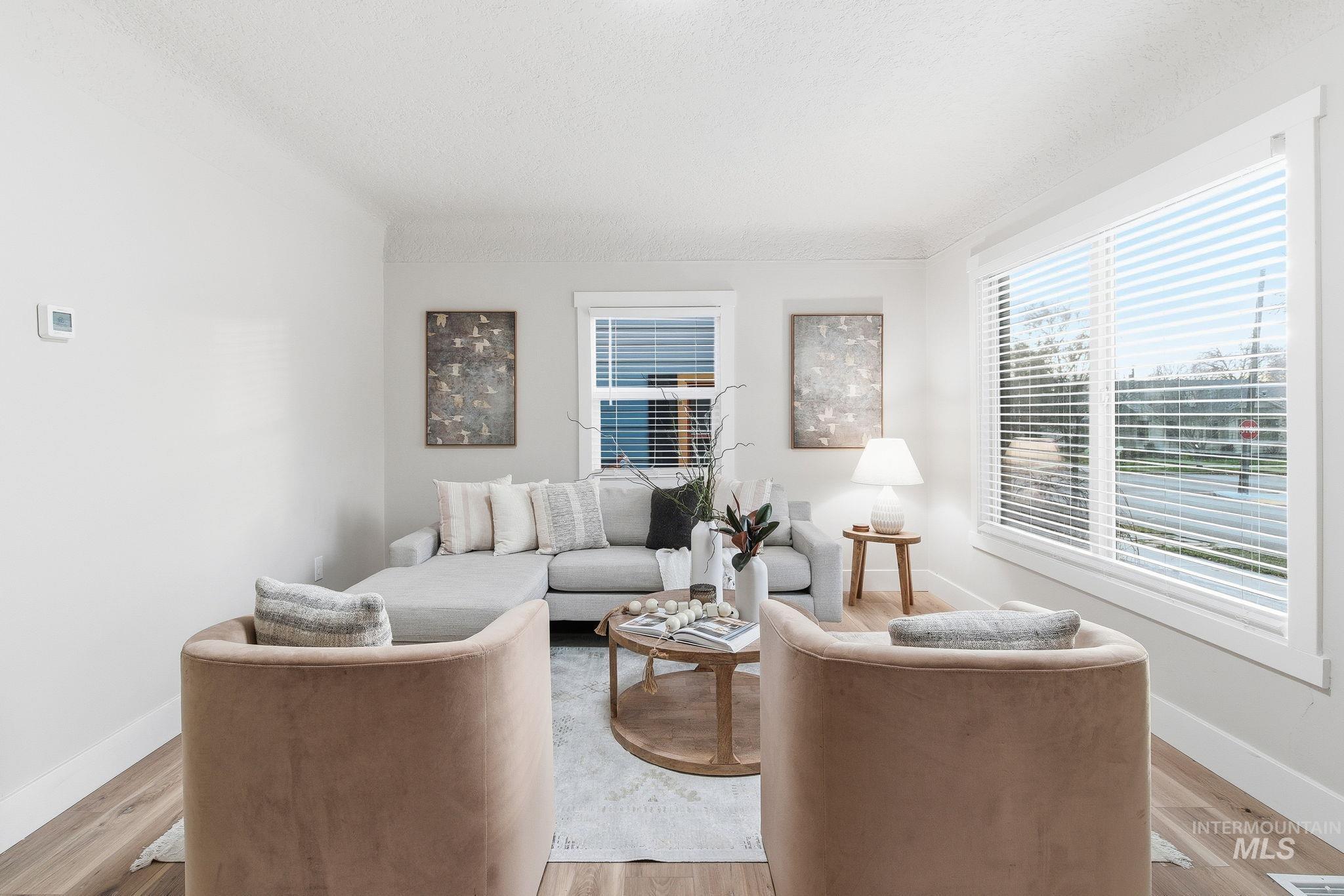 Living room featuring light wood-style flooring and a textured ceiling