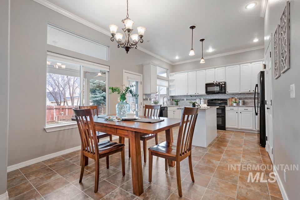 Dining area featuring ornamental molding and a chandelier