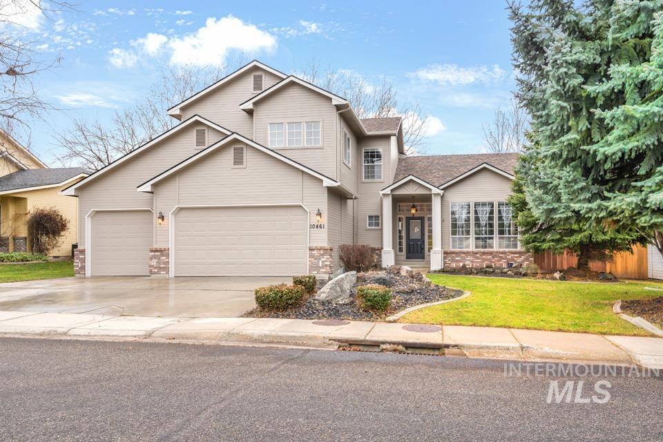 Traditional home with a front lawn, driveway, and an attached garage