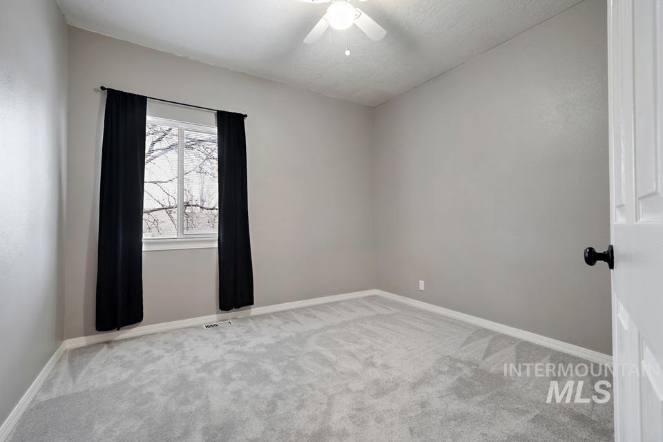Unfurnished room featuring light carpet and ceiling fan