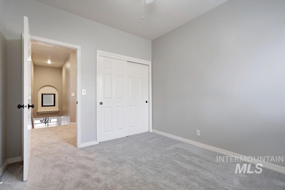 Unfurnished bedroom with light carpet and a closet