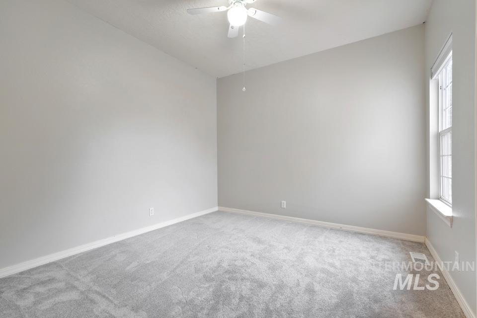 Spare room with light carpet and ceiling fan