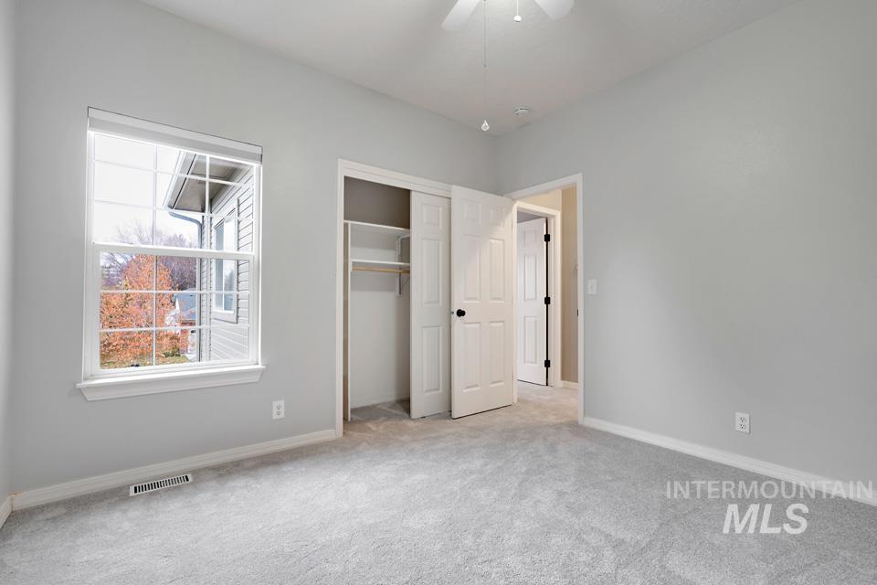Unfurnished bedroom featuring carpet, a closet, and ceiling fan