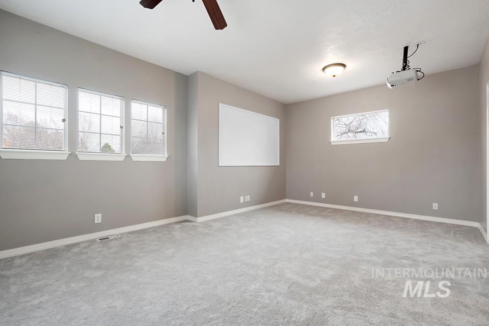Empty room featuring ceiling fan and light colored carpet