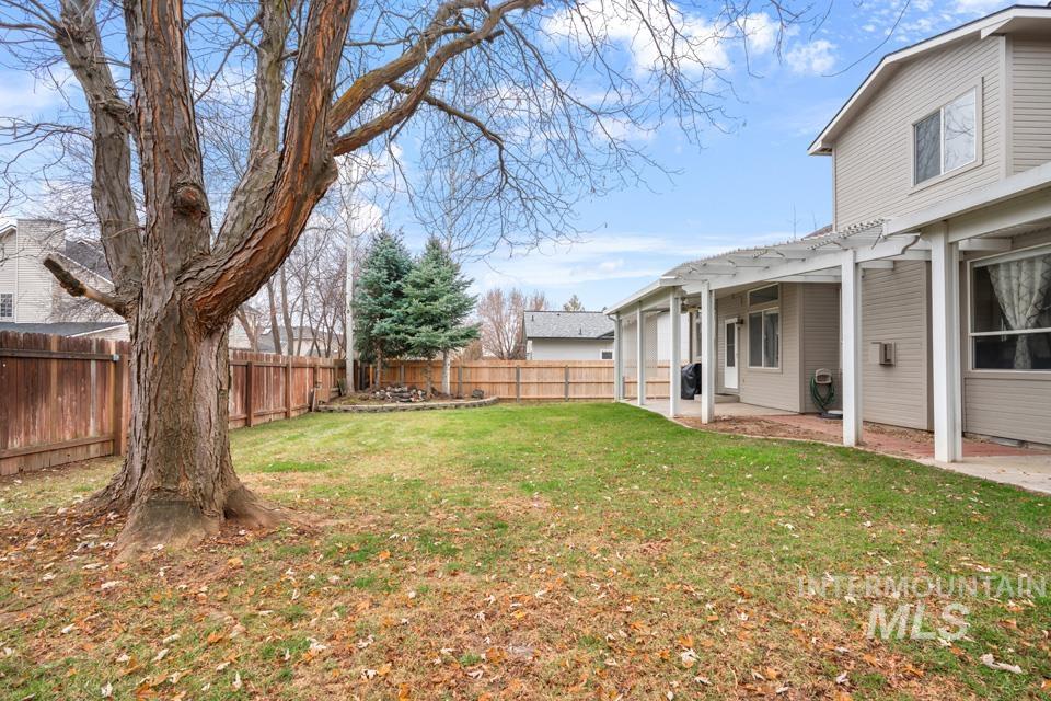Fenced backyard featuring a pergola and a patio