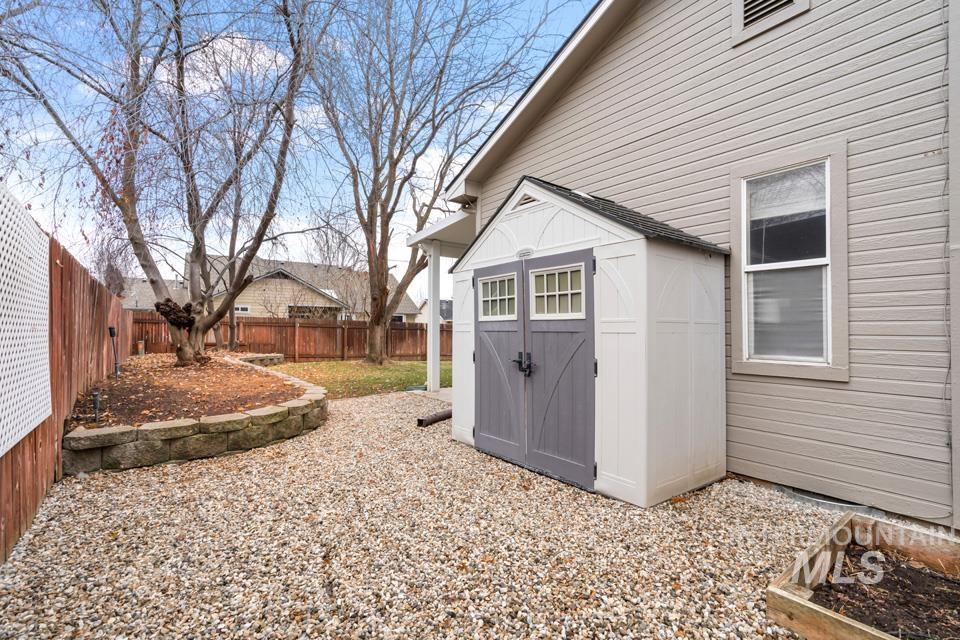 Fenced backyard featuring a shed