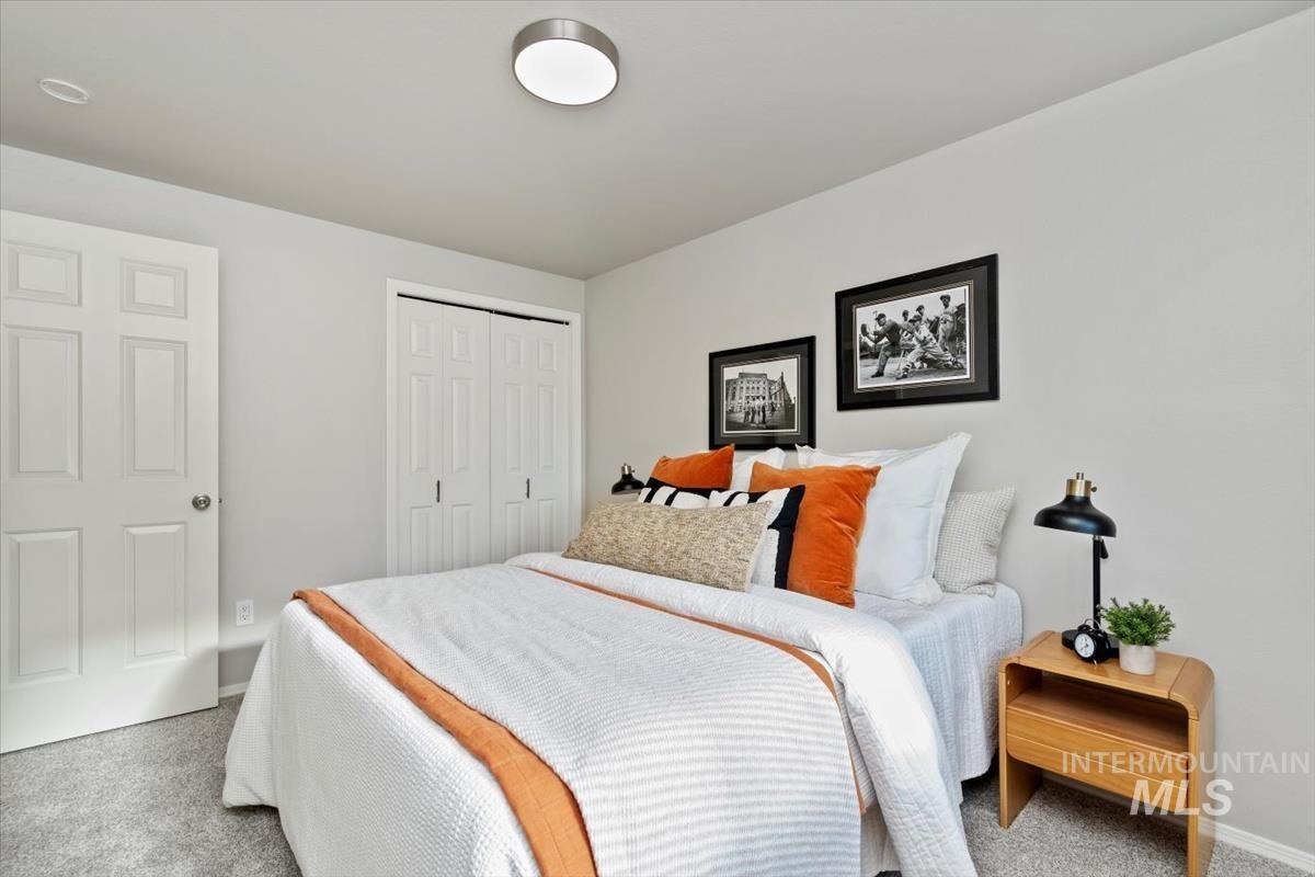 Carpeted bedroom featuring a closet and baseboards