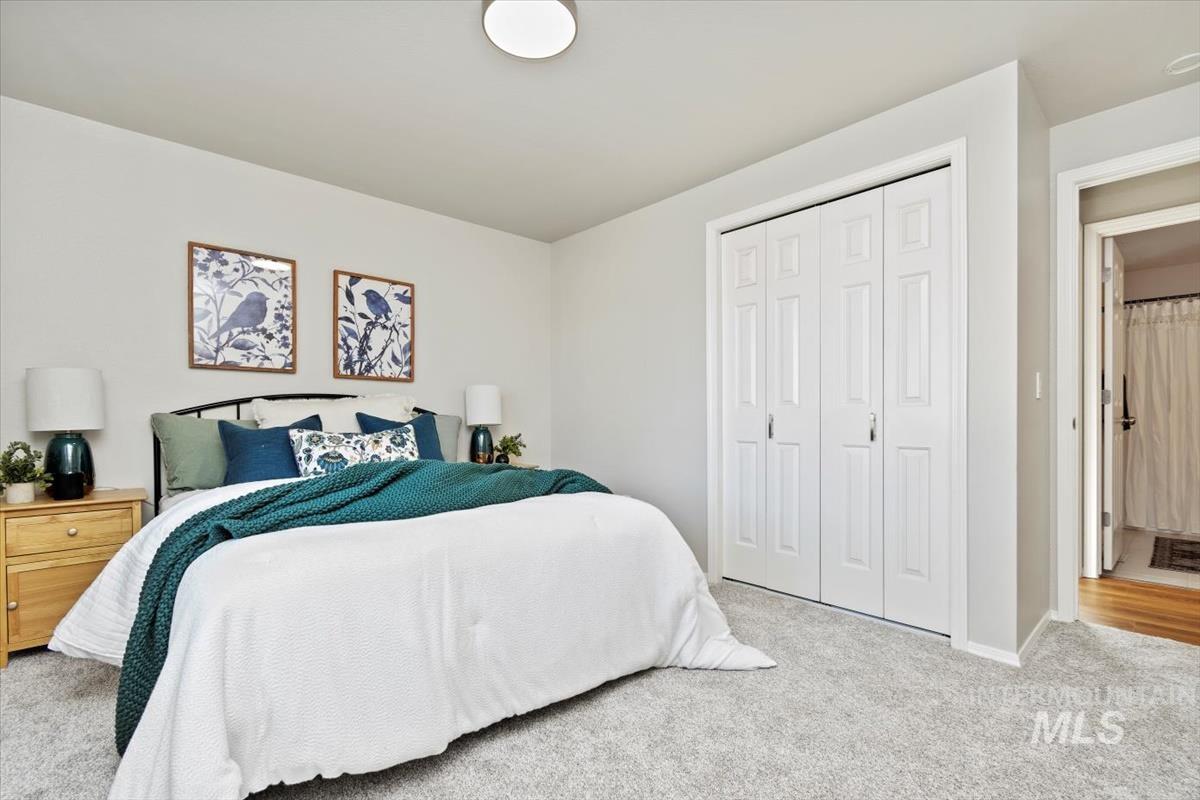 Bedroom featuring light colored carpet and a closet